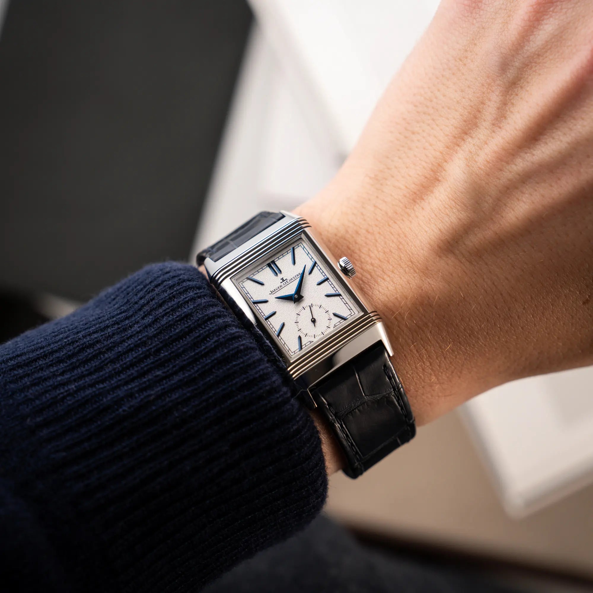 Wristshot mit der Jaeger-LeCoultre Reverso Tribute Duoface Q3908420 an einem dunkelblauen Lederband