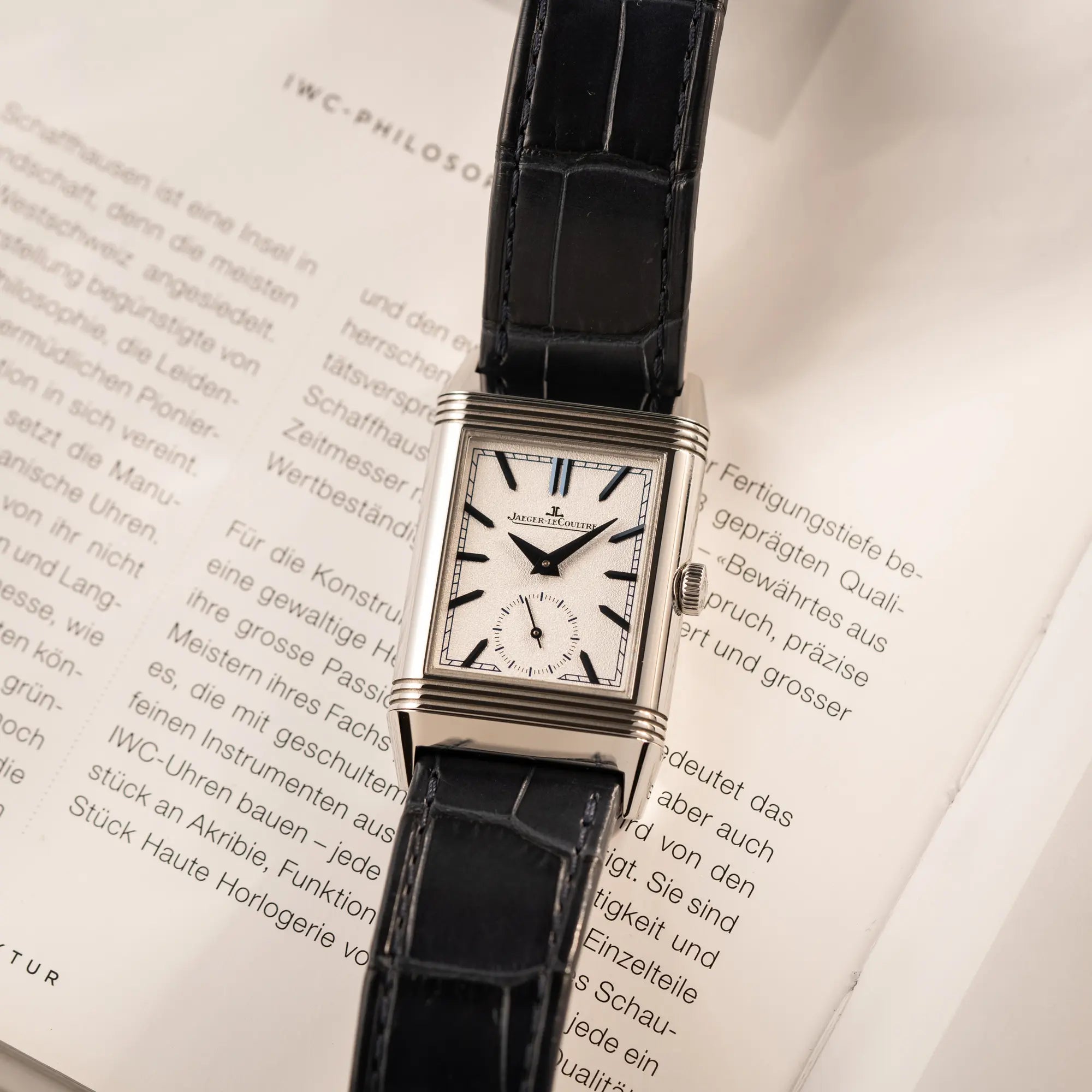 Produktfoto der Jaeger-LeCoultre Reverso Tribute Duoface Q3908420 an einem dunkelblauen Lederband bzeigt das weiß-silberne Zifferblatt