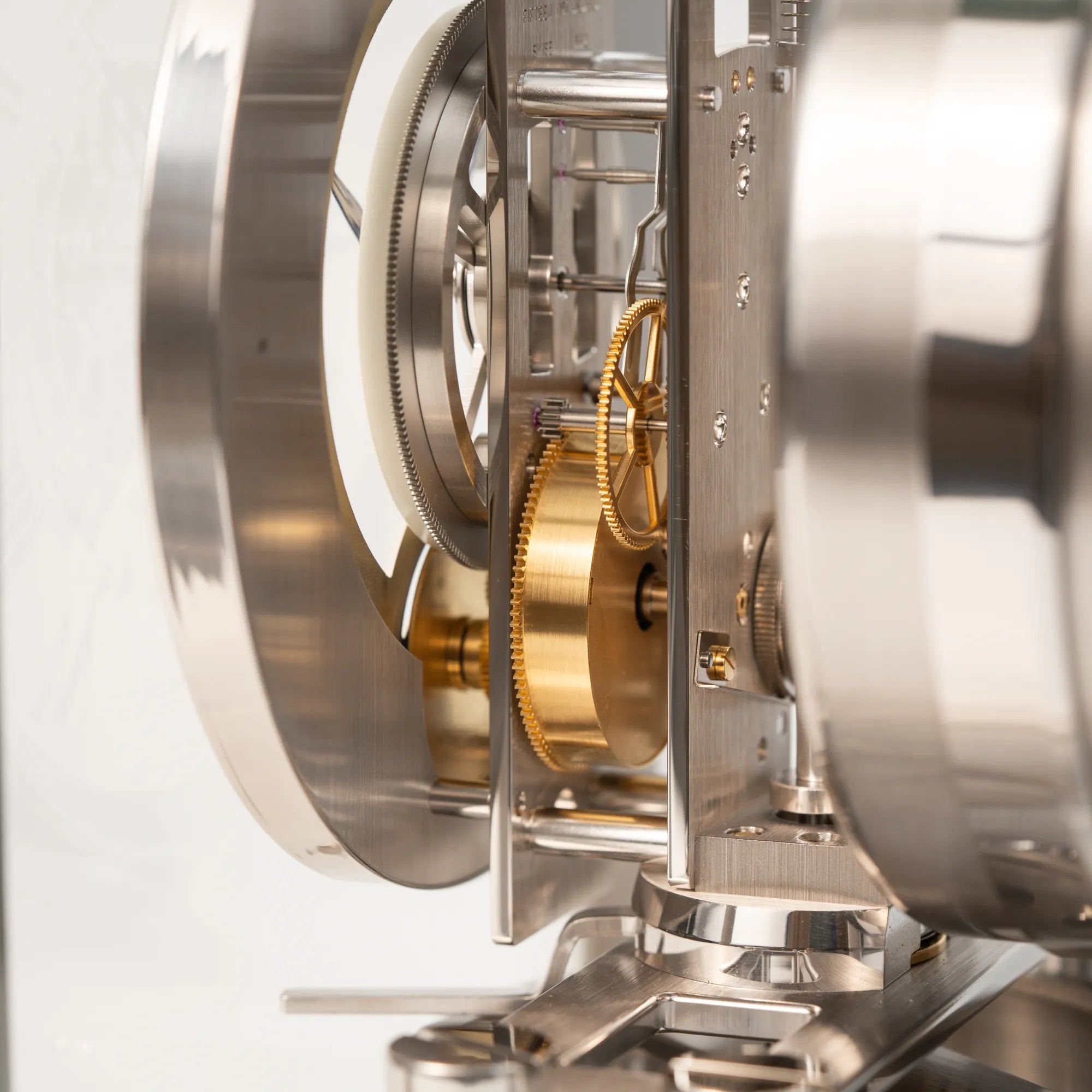 Detailaufnahme des Perpetuum Mobile Uhrwerks der Jaeger-LeCoultre Atmos Mondphase Tischuhr in rhodiniertem Stahl mit weißem Zifferblatt und blauen römischen Indizes