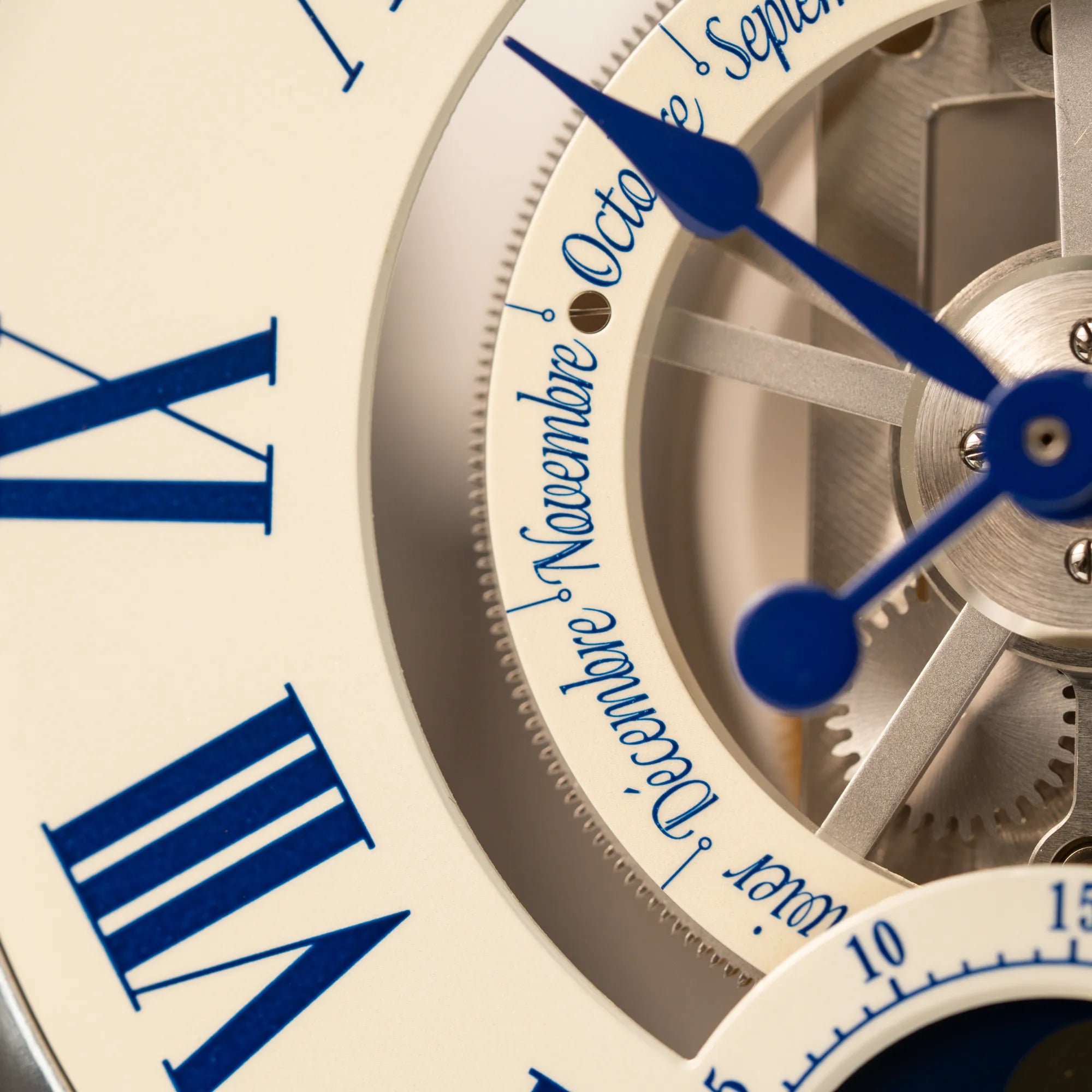 Detailaufnahme der Kalender-Anzeige von der Jaeger-LeCoultre Atmos Mondphase Tischuhr in rhodiniertem Stahl mit weißem Zifferblatt und blauen römischen Indizes