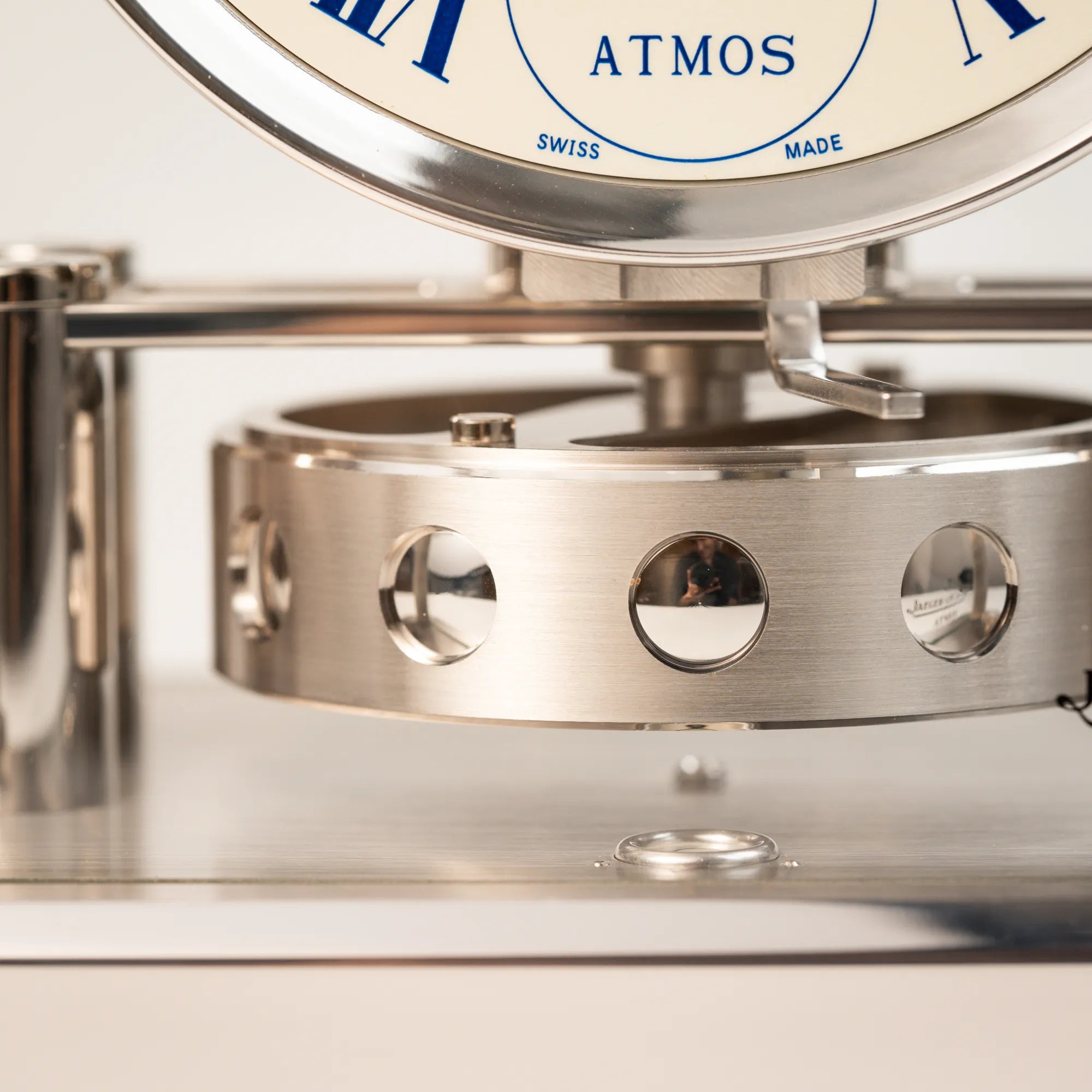 Detailaufnahme der Perpetuum Mobile Uhrwerks der Jaeger-LeCoultre Atmos Mondphase Tischuhr in rhodiniertem Stahl mit weißem Zifferblatt und blauen römischen Indizes