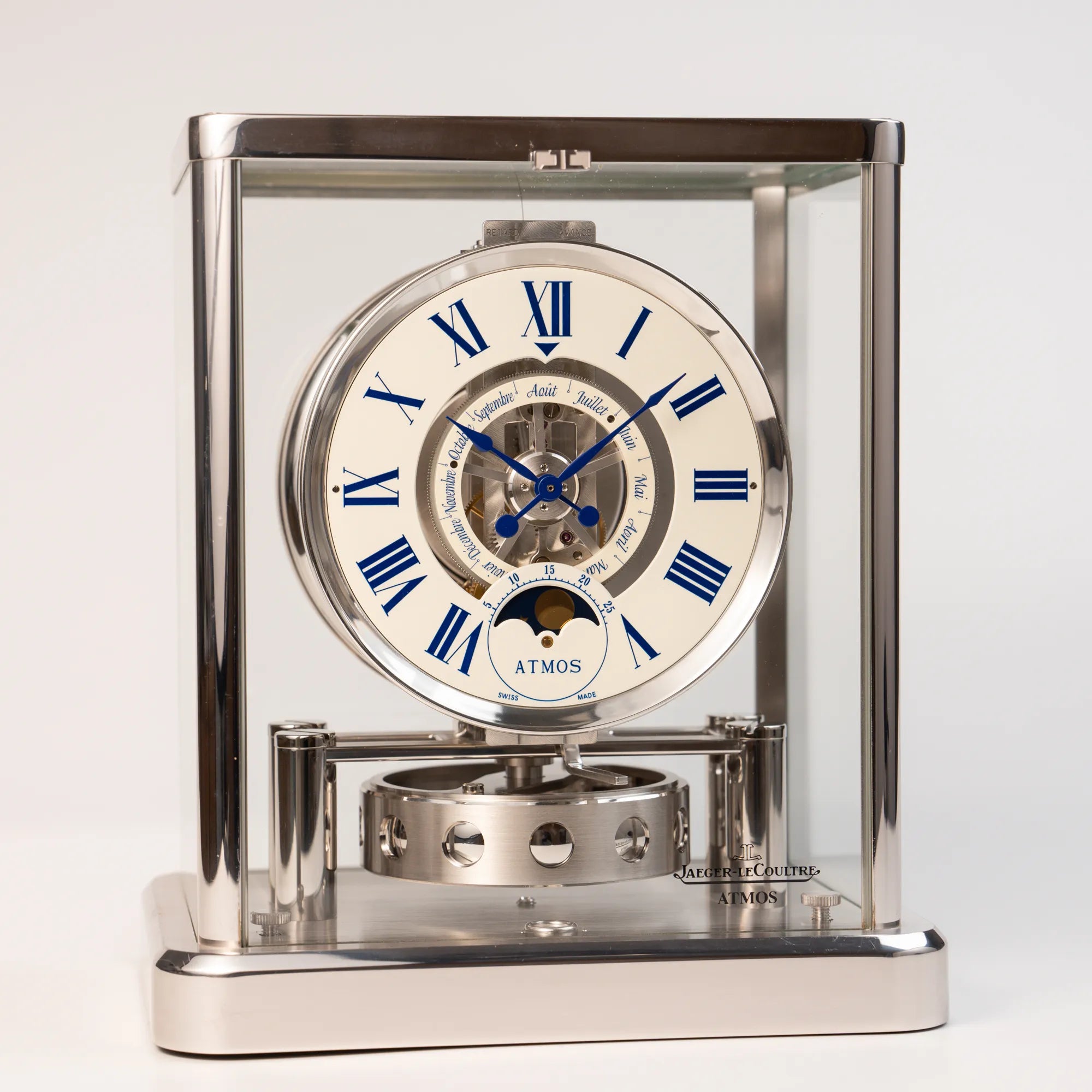 Produktfotografie der Jaeger-LeCoultre Atmos Mondphase Tischuhr in rhodiniertem Stahl mit weißem Zifferblatt und blauen römischen Indizes mit frontalem Blick auf die Tischuhr