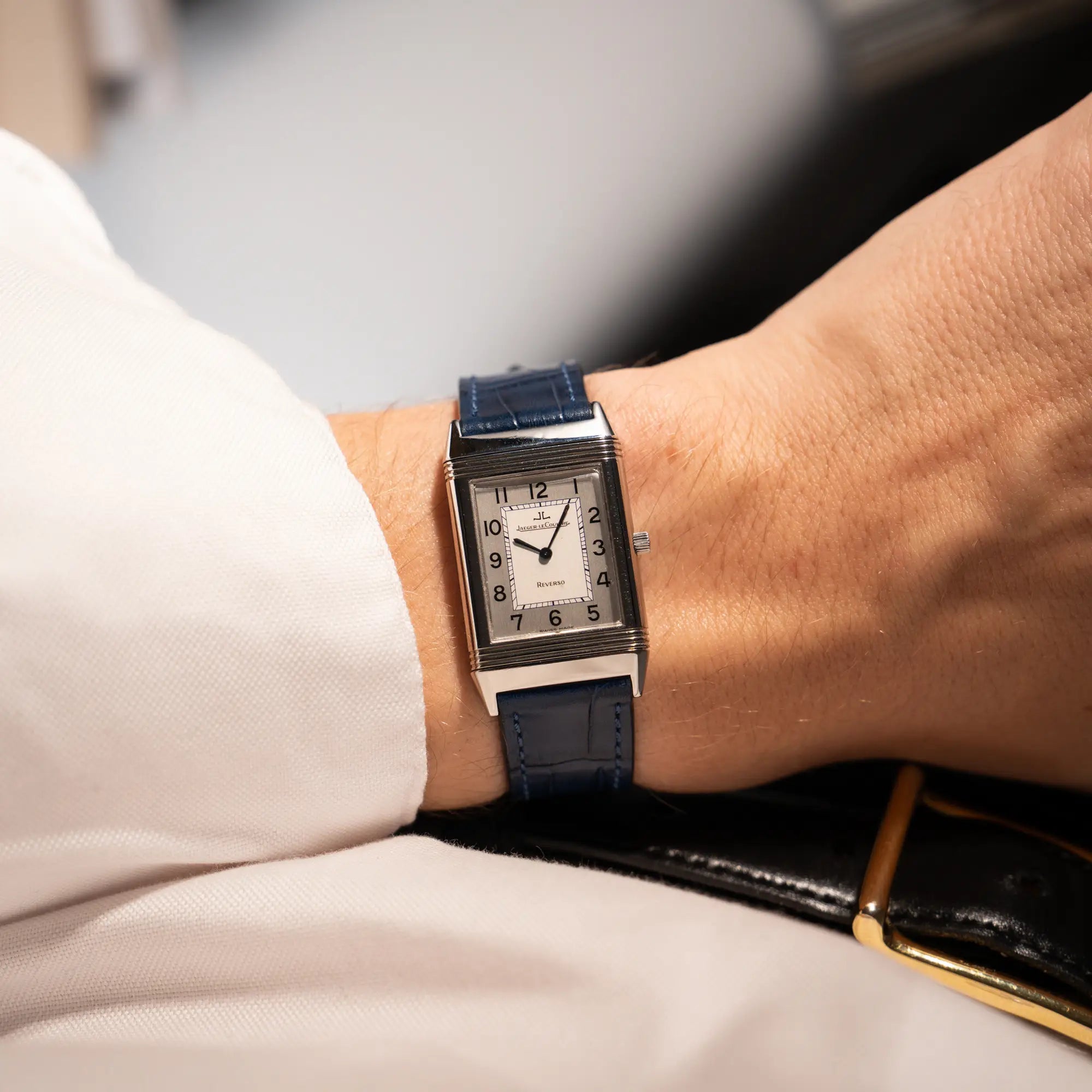 Mann trägt die Jaeger-LeCoultre Reverso Classique Medium 250.8.86 in Edelstahl an einem dunkelblauem Lederband an seinem Handgelenk