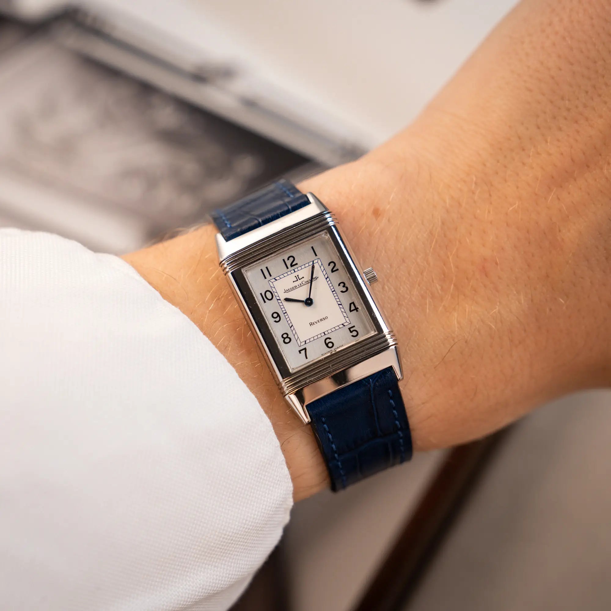 Mann trägt die Jaeger-LeCoultre Reverso Classique Medium 250.8.86 in Edelstahl an einem dunkelblauem Lederband an seinem Arm