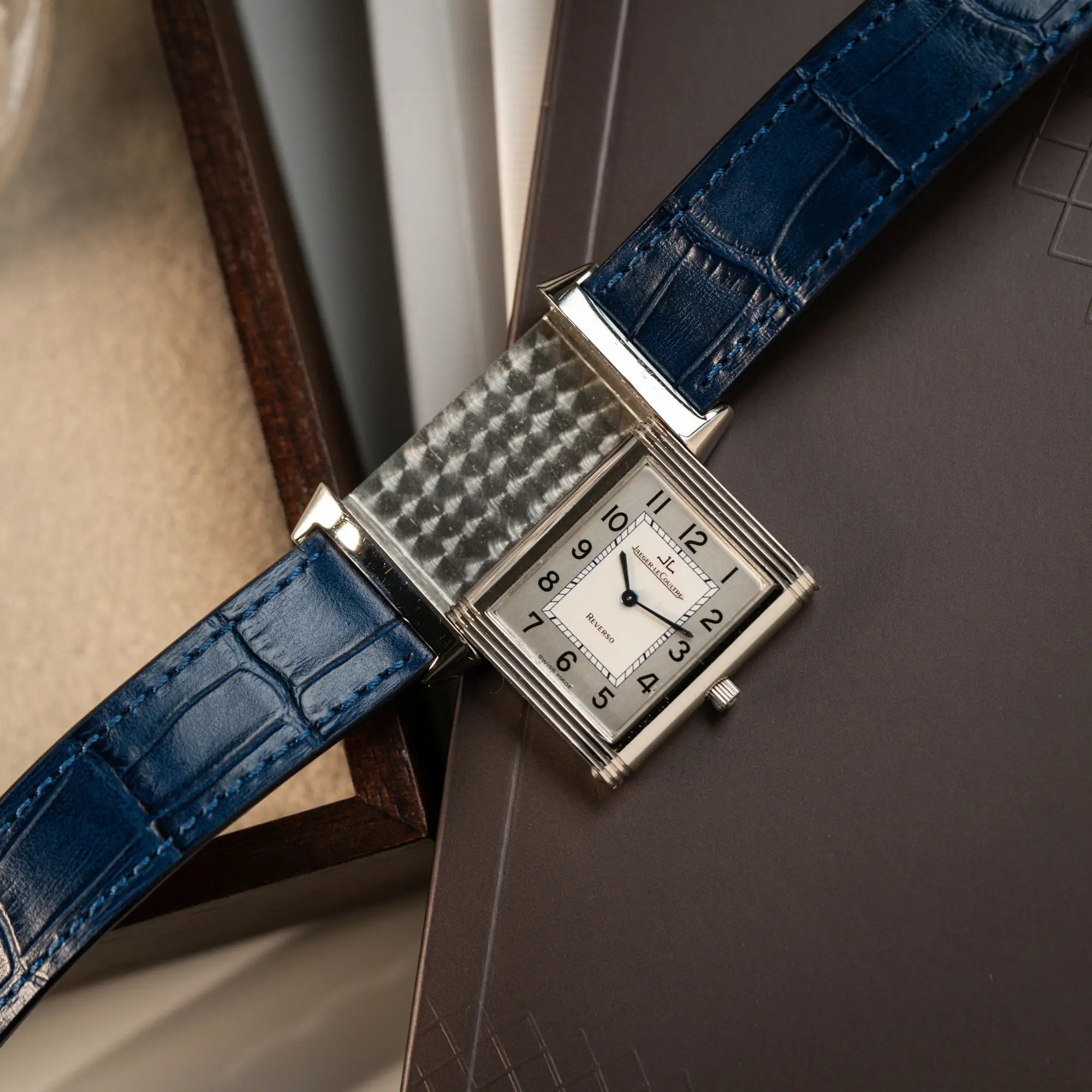 Jaeger-LeCoultre Reverso Classique Medium 250.8.86 in Edelstahl an einem dunkelblauem Lederband während der Reverso-Nechanismus betätigt wurde und deshalb die Bodenplatte zu sehen ist