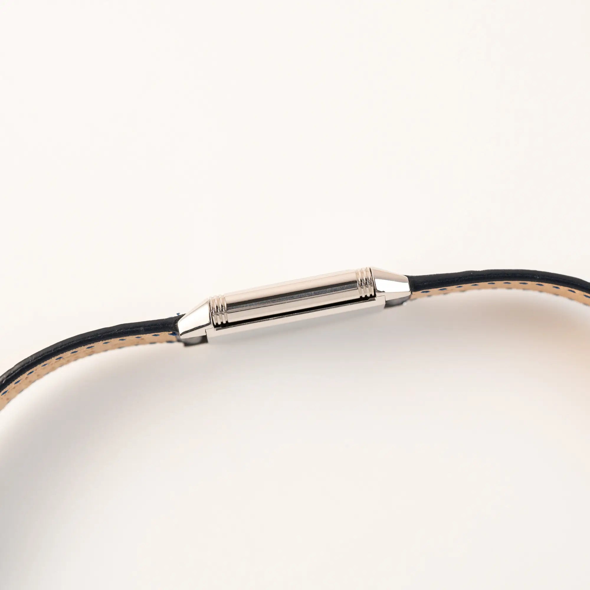 Seitliches Gehäuse der Jaeger-LeCoultre Reverso Classique Medium 250.8.86 in Edelstahl an einem dunkelblauem Lederband