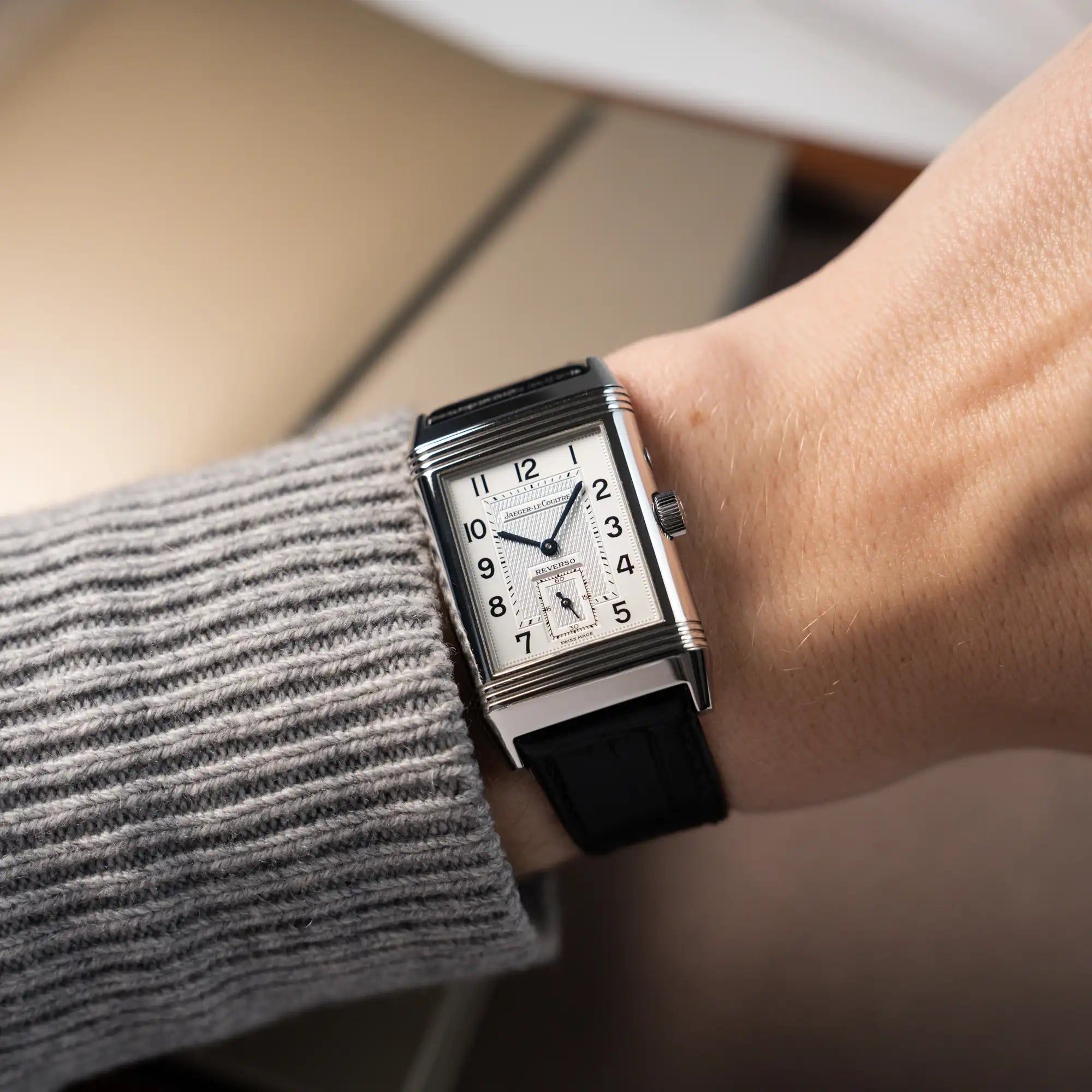 Mann trägt die Jaeger LeCoultre Reverso Duoface 270.8.54 in Stahl mit Blick auf das weiße Zifferblatt an seinem Handegelenk
