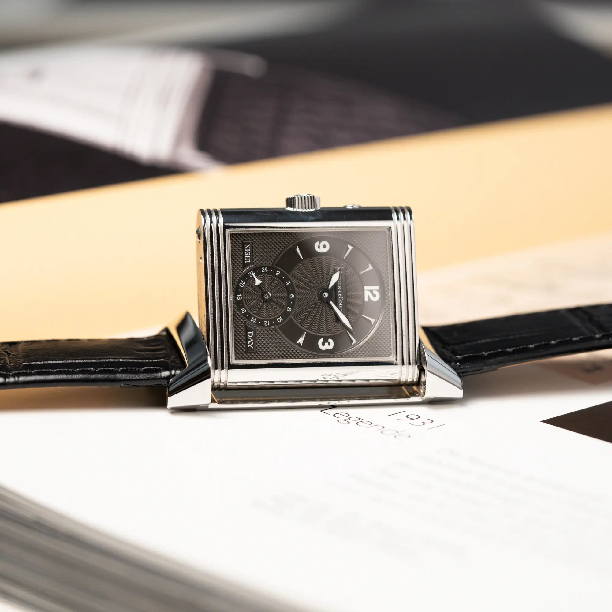 Produktfotgradie der Jaeger LeCoultre Reverso Duoface 270.8.54 in Stahl mit Blick auf das schwarze Zifferblatt, während die Uhr gerade ausgeklappt sit