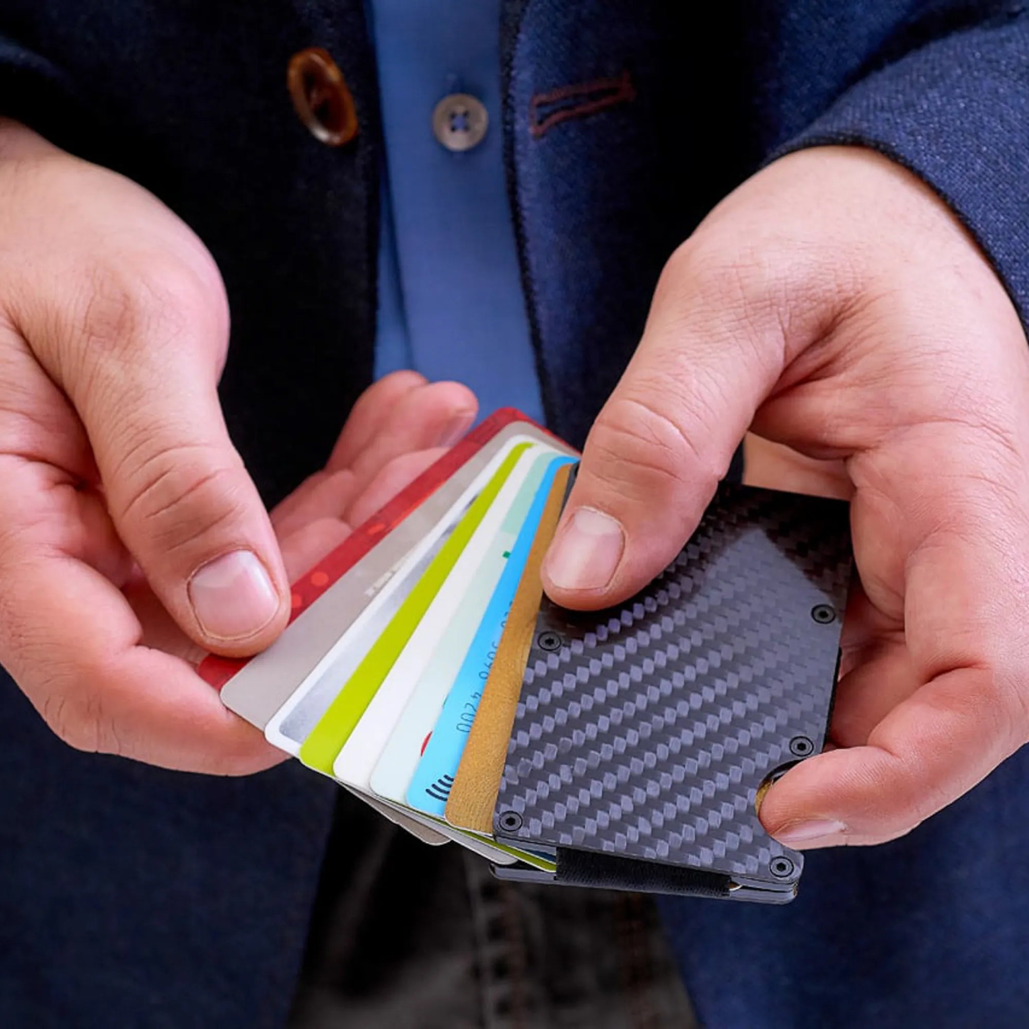 Mann hält das Carbon Tech Wallet in seiner Hand und zieht gerade die Karten hervor