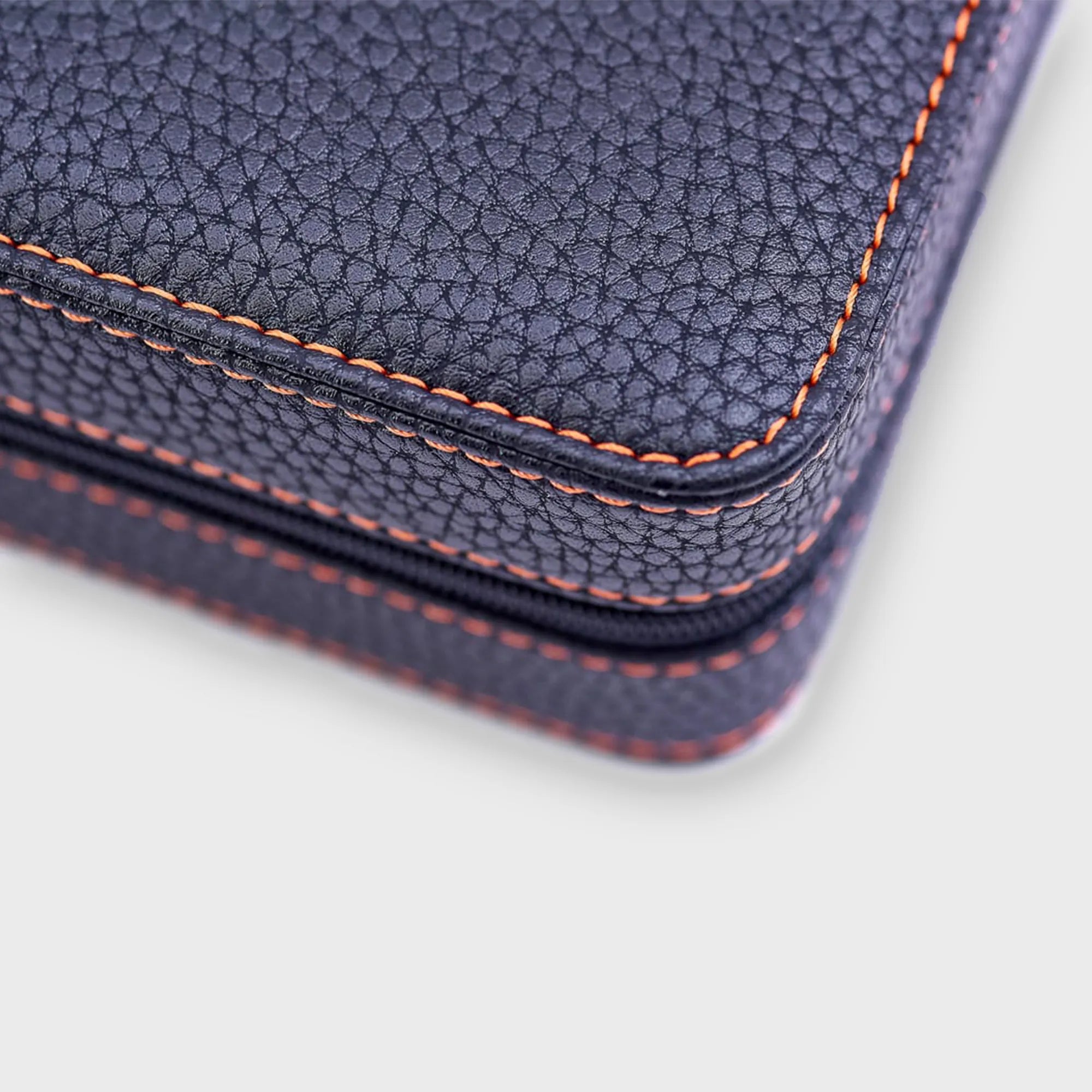 Detailaufnahme des schwarzen PU Leders des Uhrenetuis von Leanschi mit orangen Ziernähten