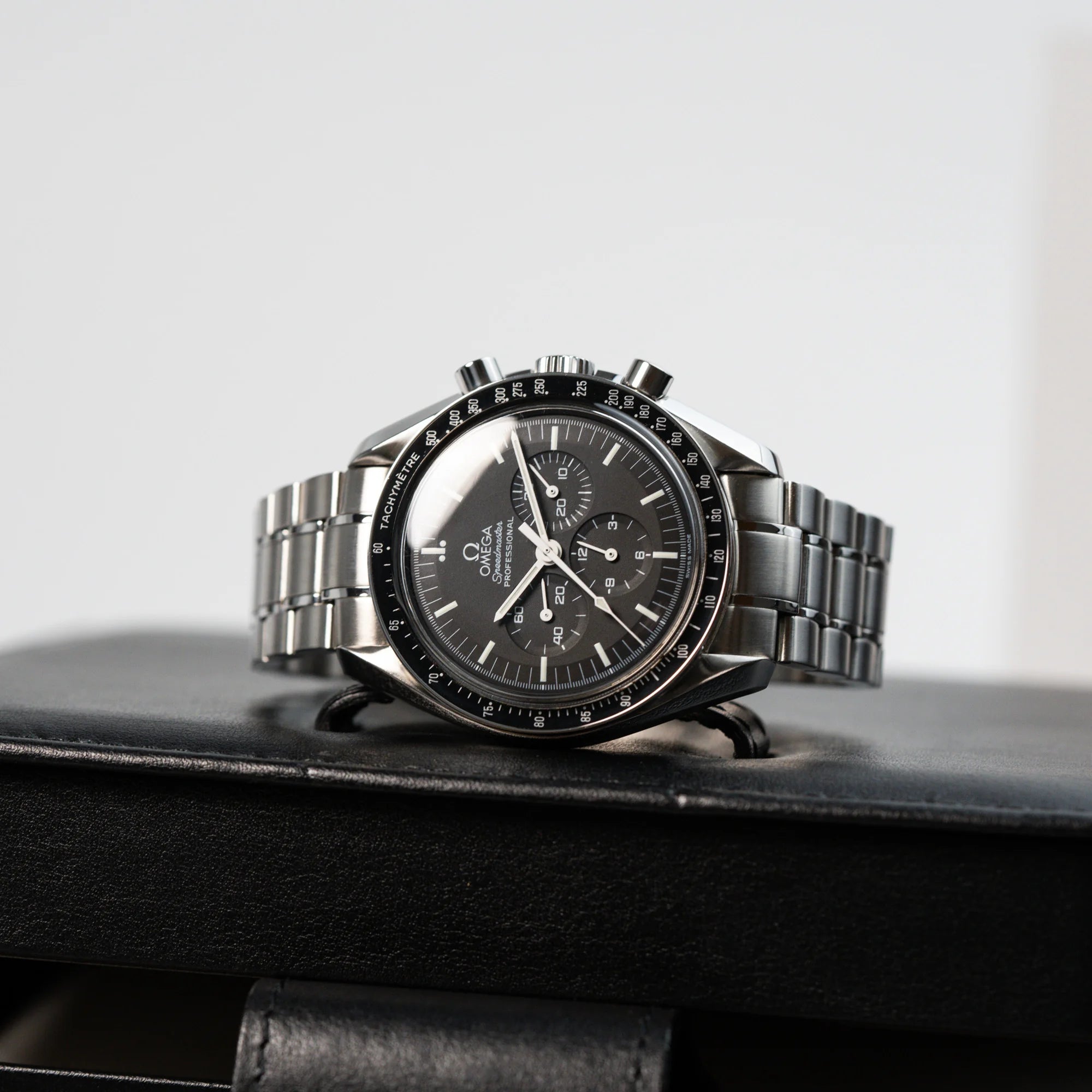 Omega Speedmaster Moonwatch Professional mit der Referenz 357.50.00 mit dem klassischen schwarzen Zifferblatt liegt auf der originalen Uhrenbox
