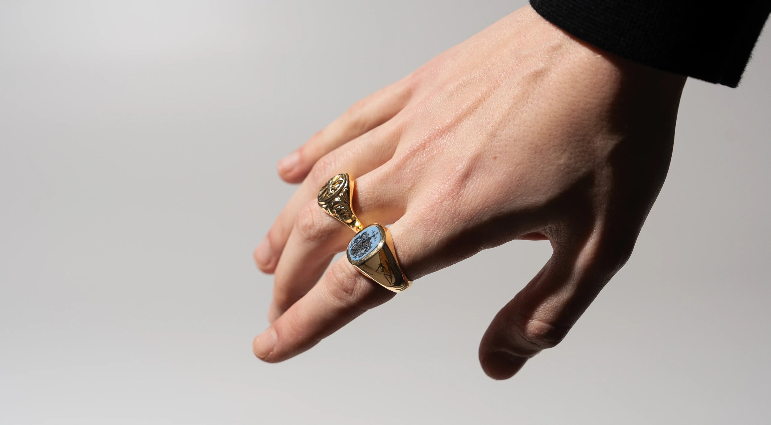 Maennerhand mit zwei Siegelringen aus Gelbgold, die von Schmuckatelier Lang angefertigt wurden