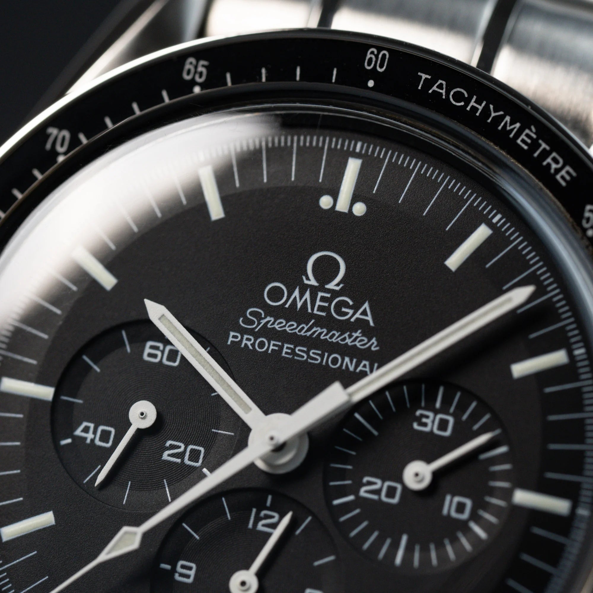 Makroaufnahme des klassischen schwarzen Zifferblatts der Omega Speedmaster Moonwatch Professional mit der Referenz 357.50.00