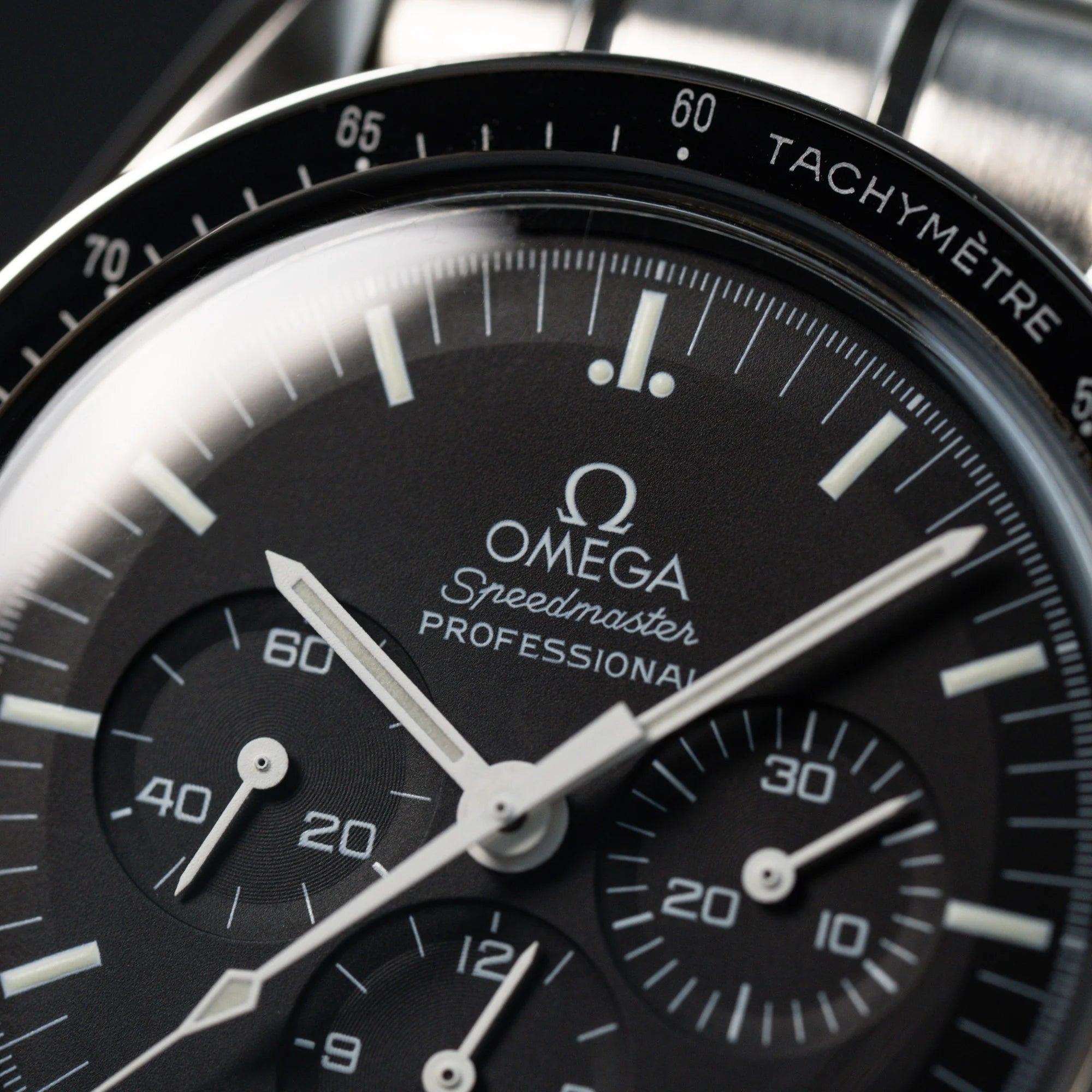 Makroaufnahme des klassischen schwarzen Zifferblatts der Omega Speedmaster Moonwatch Professional mit der Referenz 357.50.00