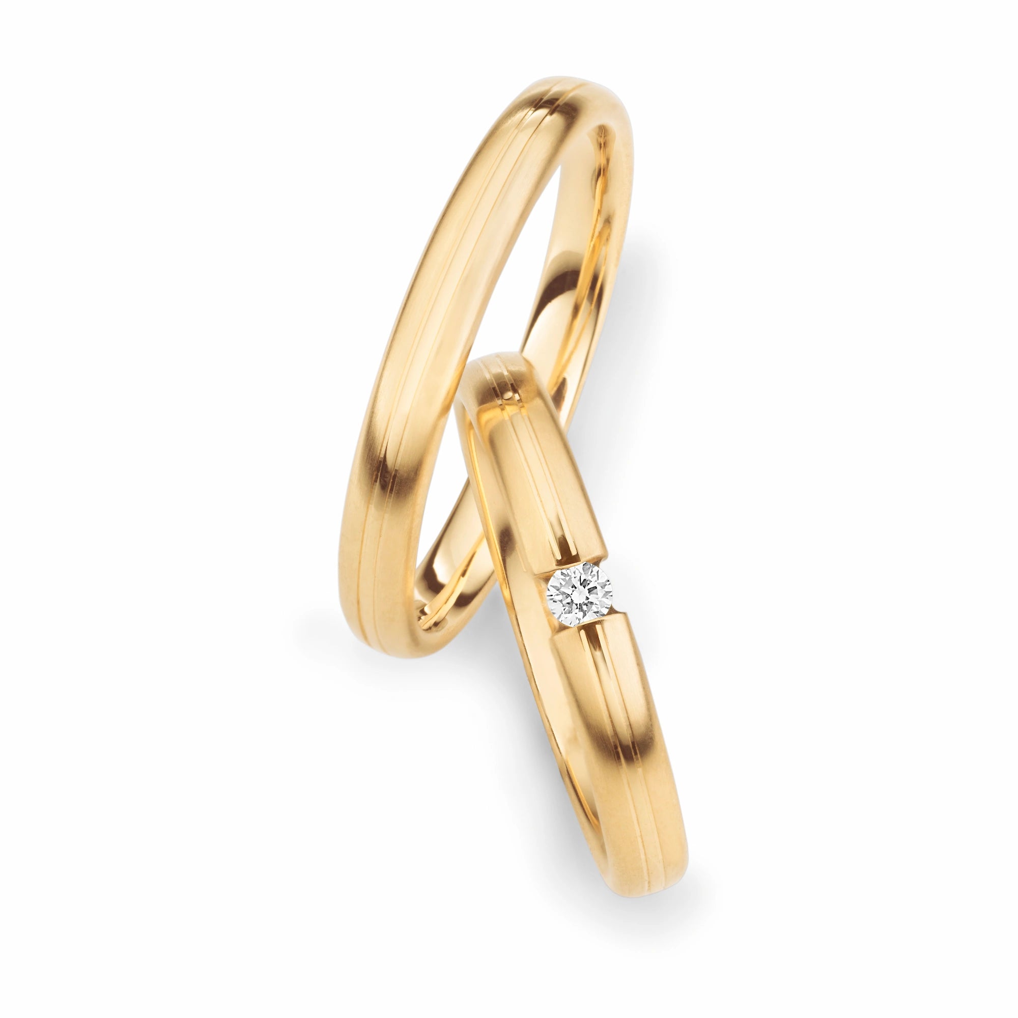 Produktfotografie des gelbgoldenen Max Kemper Trauringpaars mit einem frei stehenden, gefassten zentralen Brillanten auf dem Damenring