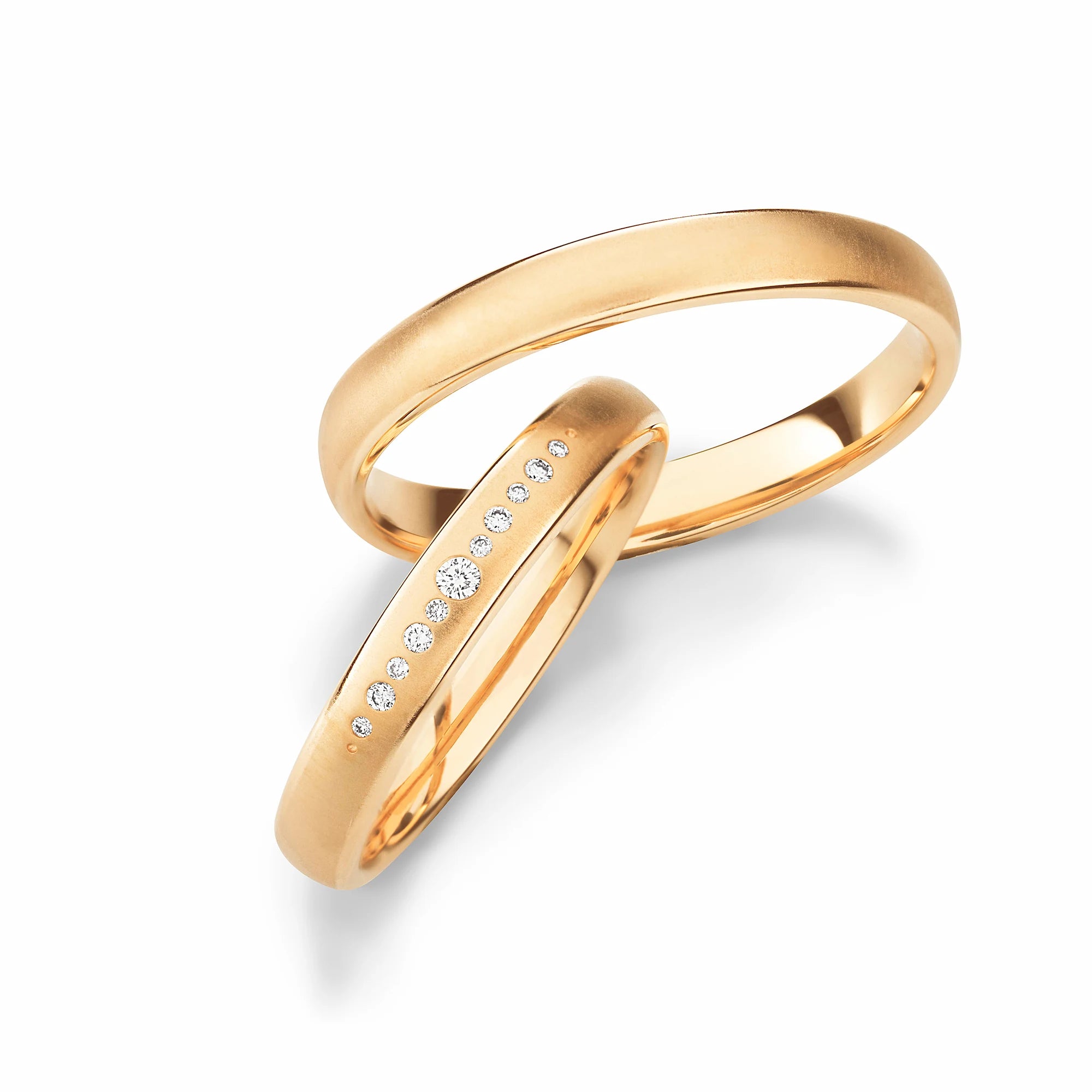 Produktfotografie des gelbgoldenen Max Kemper Trauringpaars mit mit einer Diamantreihe mit verschieden großen Brillanten als Verzierung
