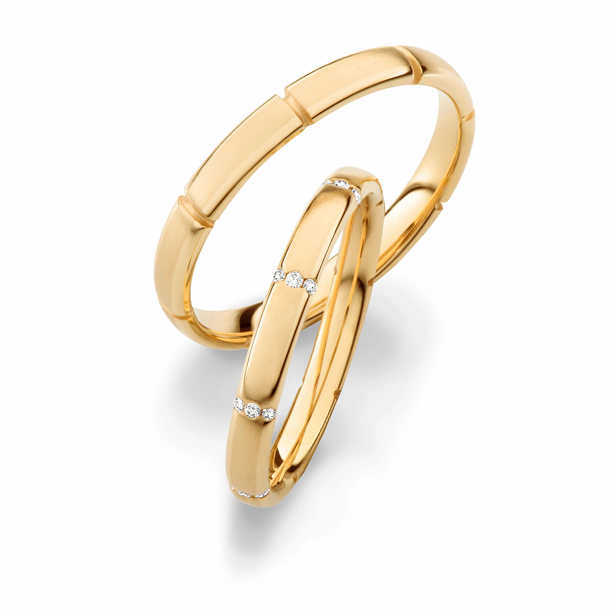 Produktfotografie des gelbgoldenen Max Kemper Trauringpaars mit quer platzierten 3er Diamant-Sets, die sich in regelmäßigen Abständen wiederholen