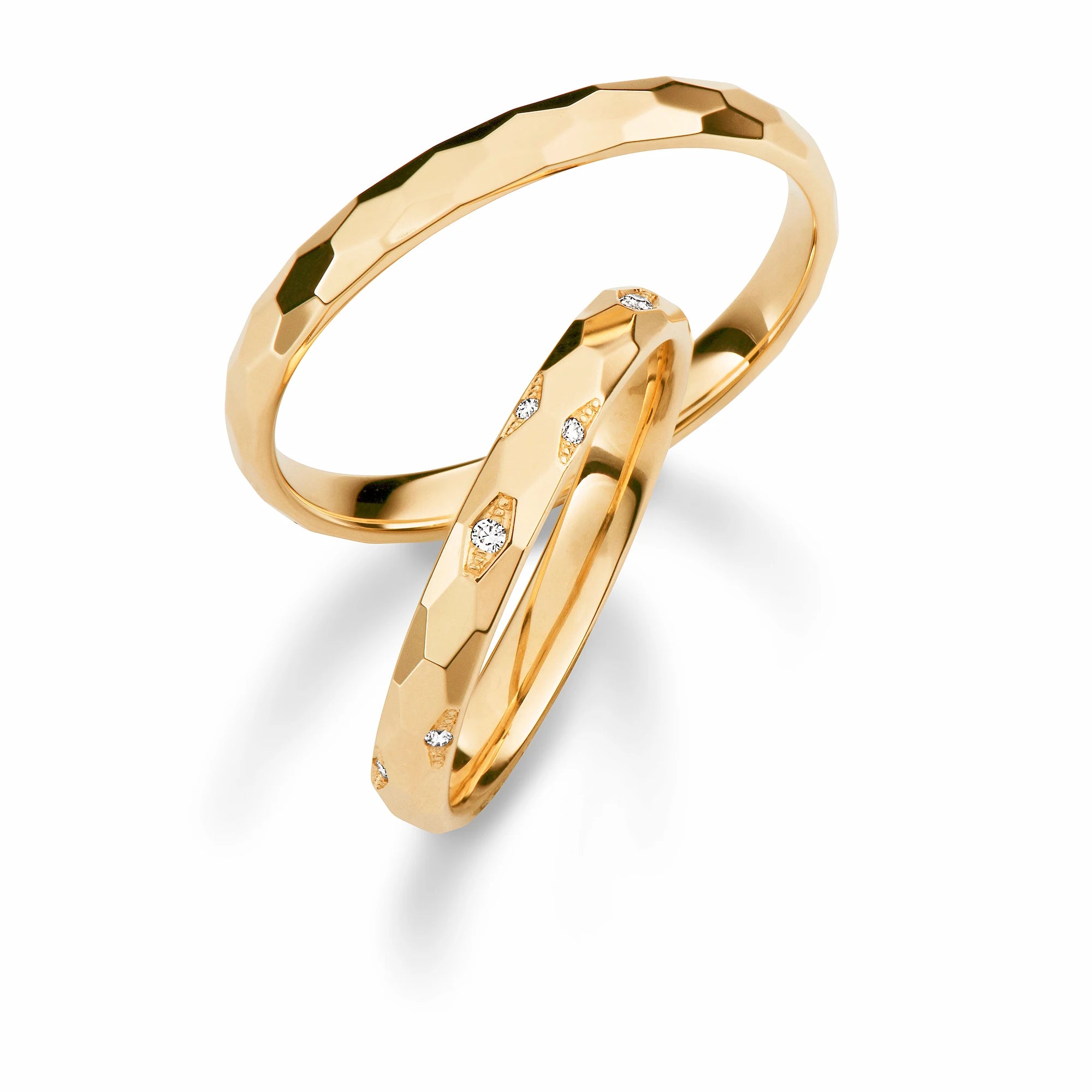 Produktfotografie des gelbgoldenen Max Kemper Trauringpaars mit Honey-Comb-Oberfläche und liebevoll platzierten Diamanten auf dem Damenring