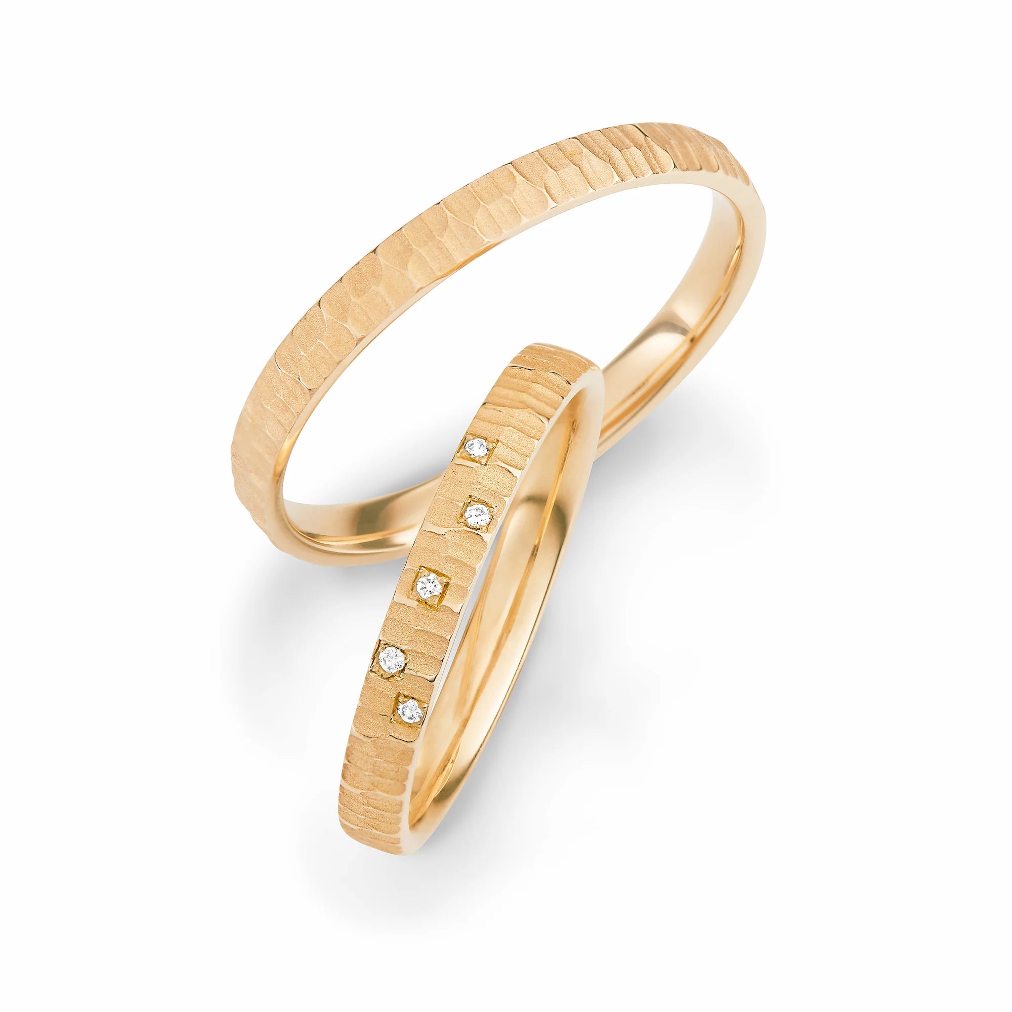 Produktfotografie des gelbgoldenen Max Kemper Trauringpaars mit grober Oberfläche und 5 Diamanten bei dem Damenring