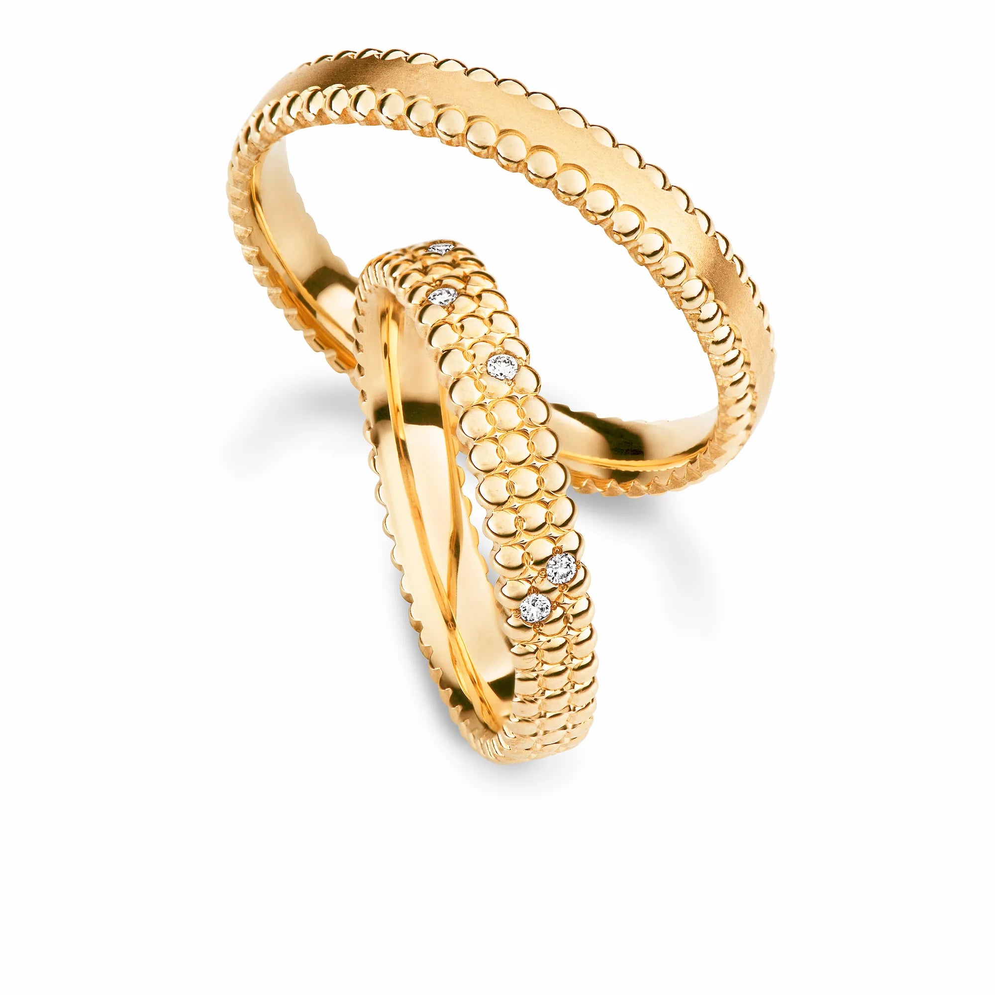 Produktfotografie des gelbgoldenen Max Kemper Trauringpaars mit einer einzigartigen Oberflächenstruktur mit Kugelelementen und Diamanten im Damenring