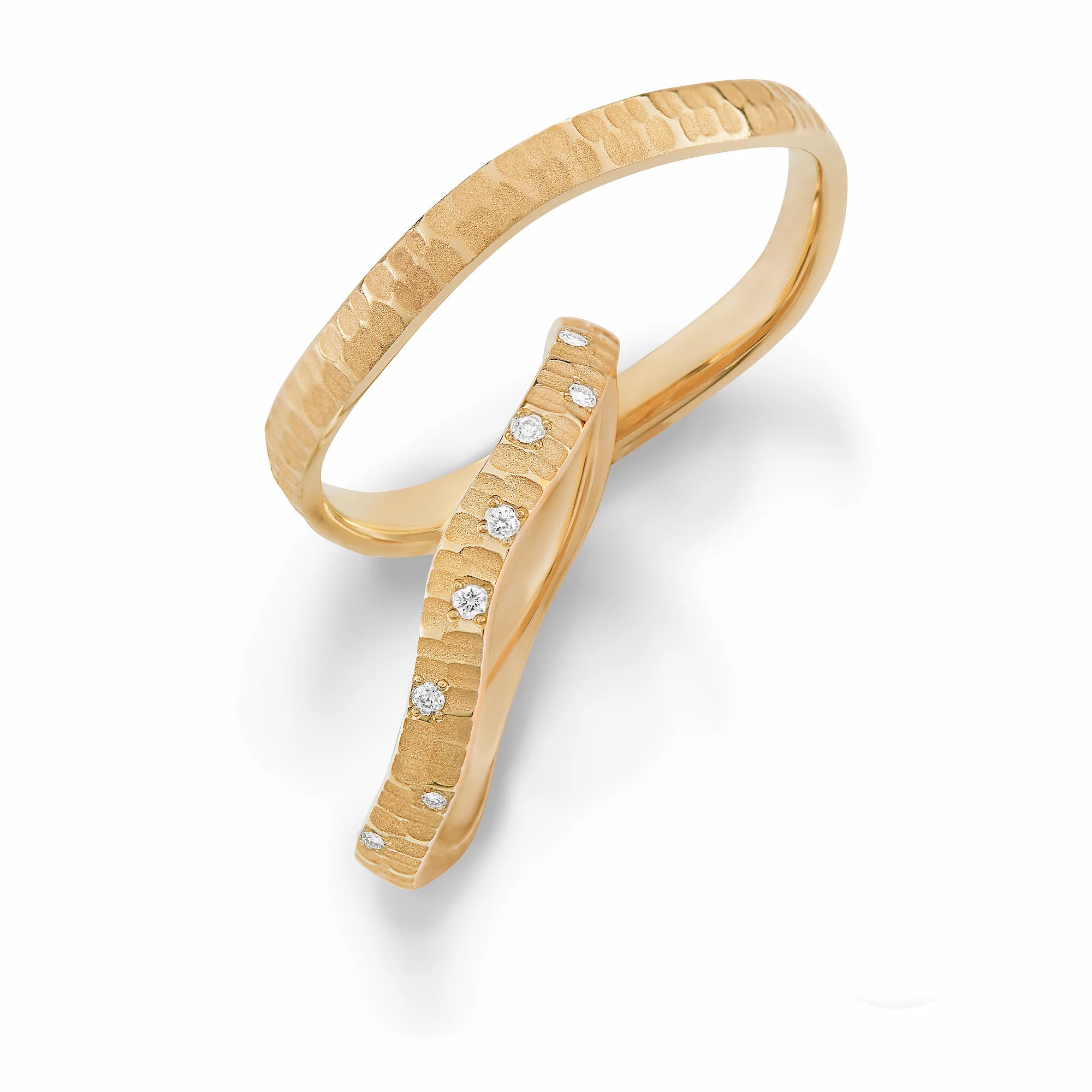 Produktfotografie des gelbgoldenen Max Kemper Trauringpaars mit einer organischen Form und einzigartiger grober Oberflächenstruktur und Diamanten im Damenring