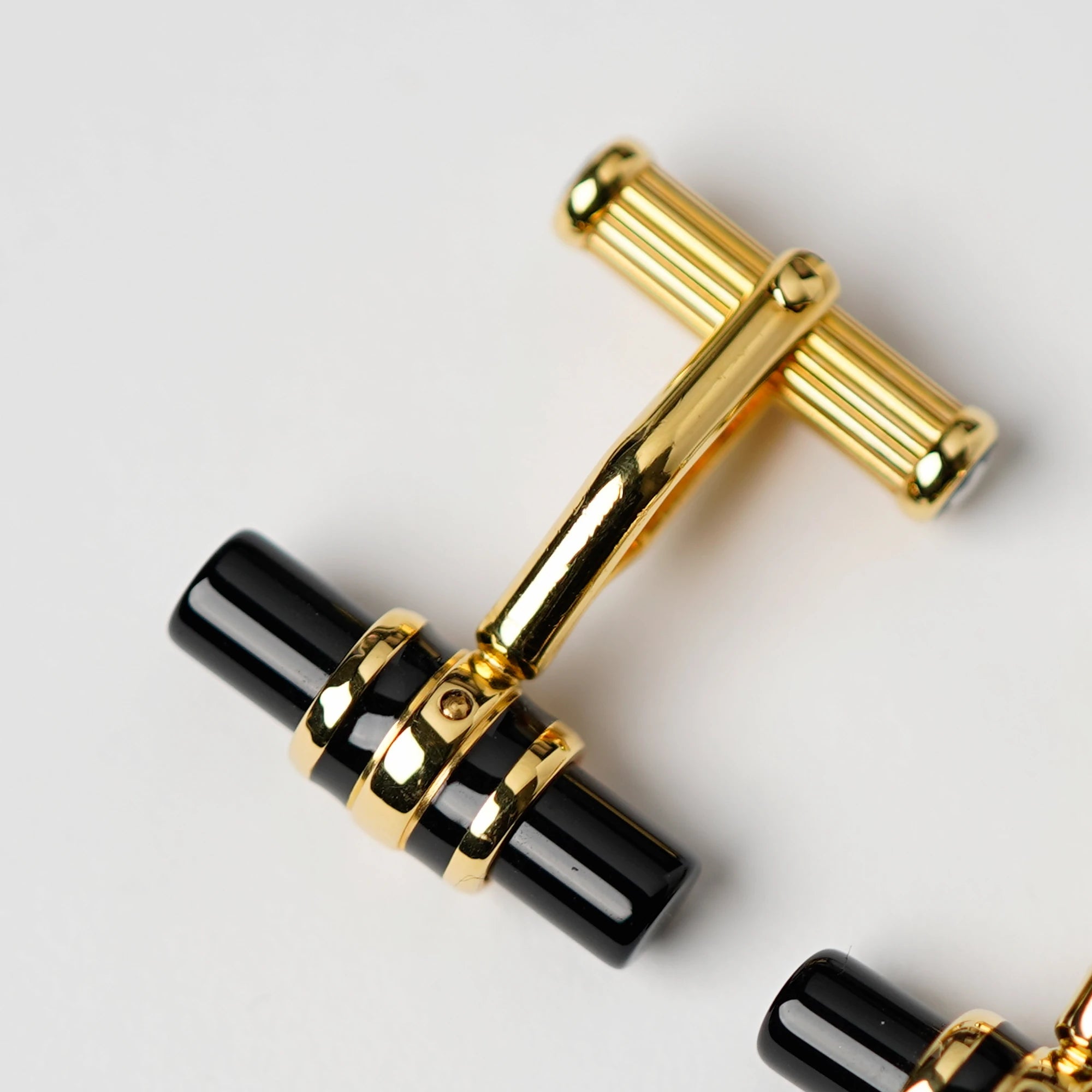 Detailaufnahme der Gold-plattinierten Manschettenknöpfe Elegance Bar 3 mit Onyx-Stift von Mont Blanc