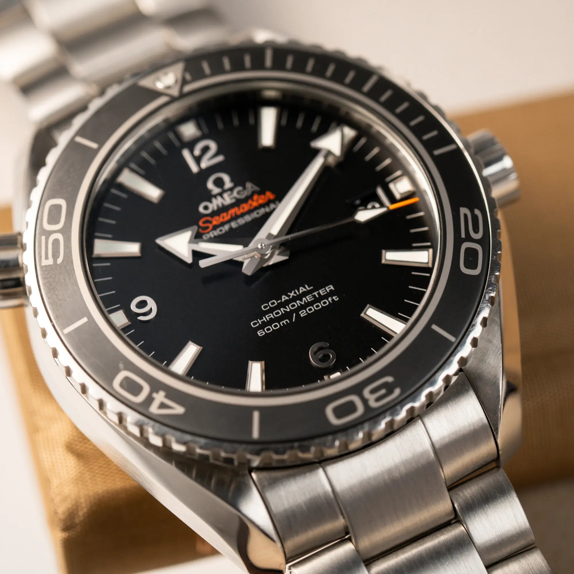 Detailaufnahme der Omega Seamaster Planet Ocean 232.30.46.21.01.001 mit 45mm Gehäuse und schwarzem Zifferblatt mit orangen Details
