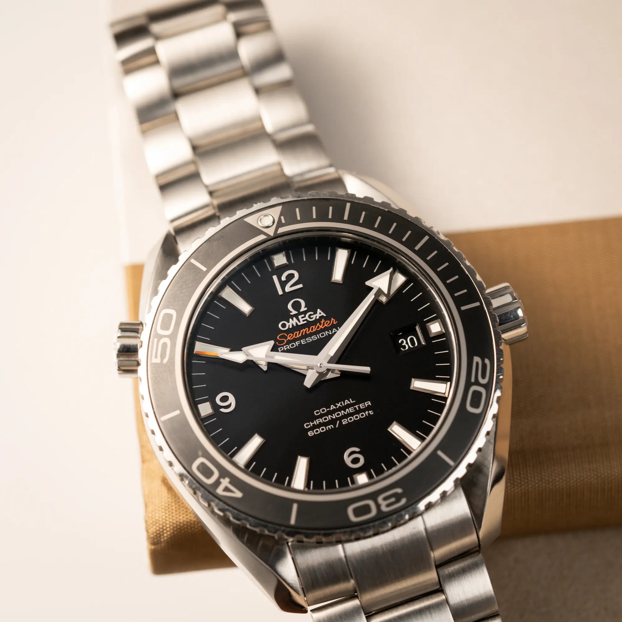 Detailaufnahme der Omega Seamaster Planet Ocean 232.30.46.21.01.001 mit 45mm Gehäuse und schwarzem Zifferblatt mit orangen Details, sowie einem orangen Detail des Sekundenzeigers