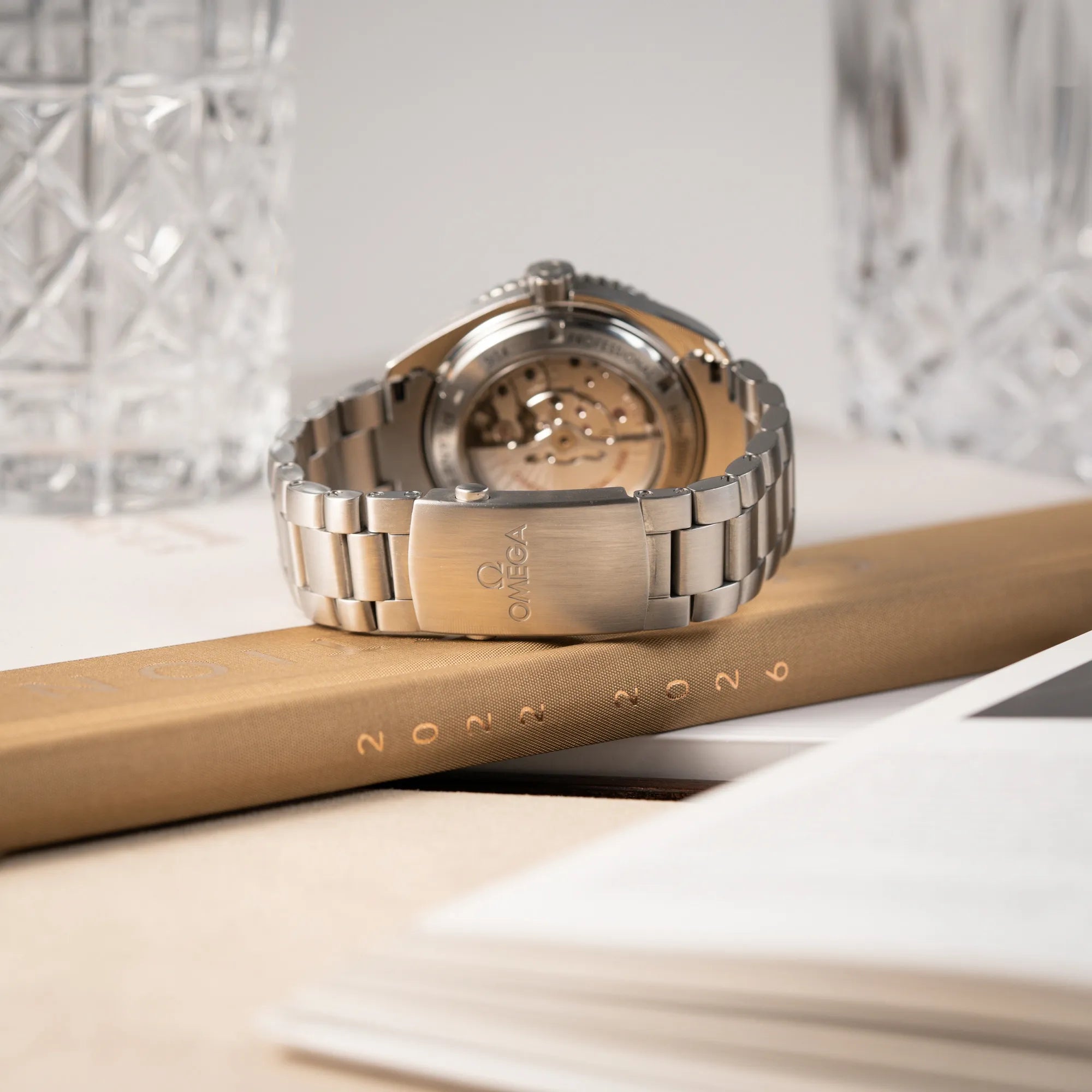 Produktfotografie der Omega Seamaster Planet Ocean 232.30.46.21.01.001 mit 45mm Gehäuse und schwarzem Zifferblatt mit orangen Details zeigt die geschlossene Omega-Faltschliesse und deren Zustand