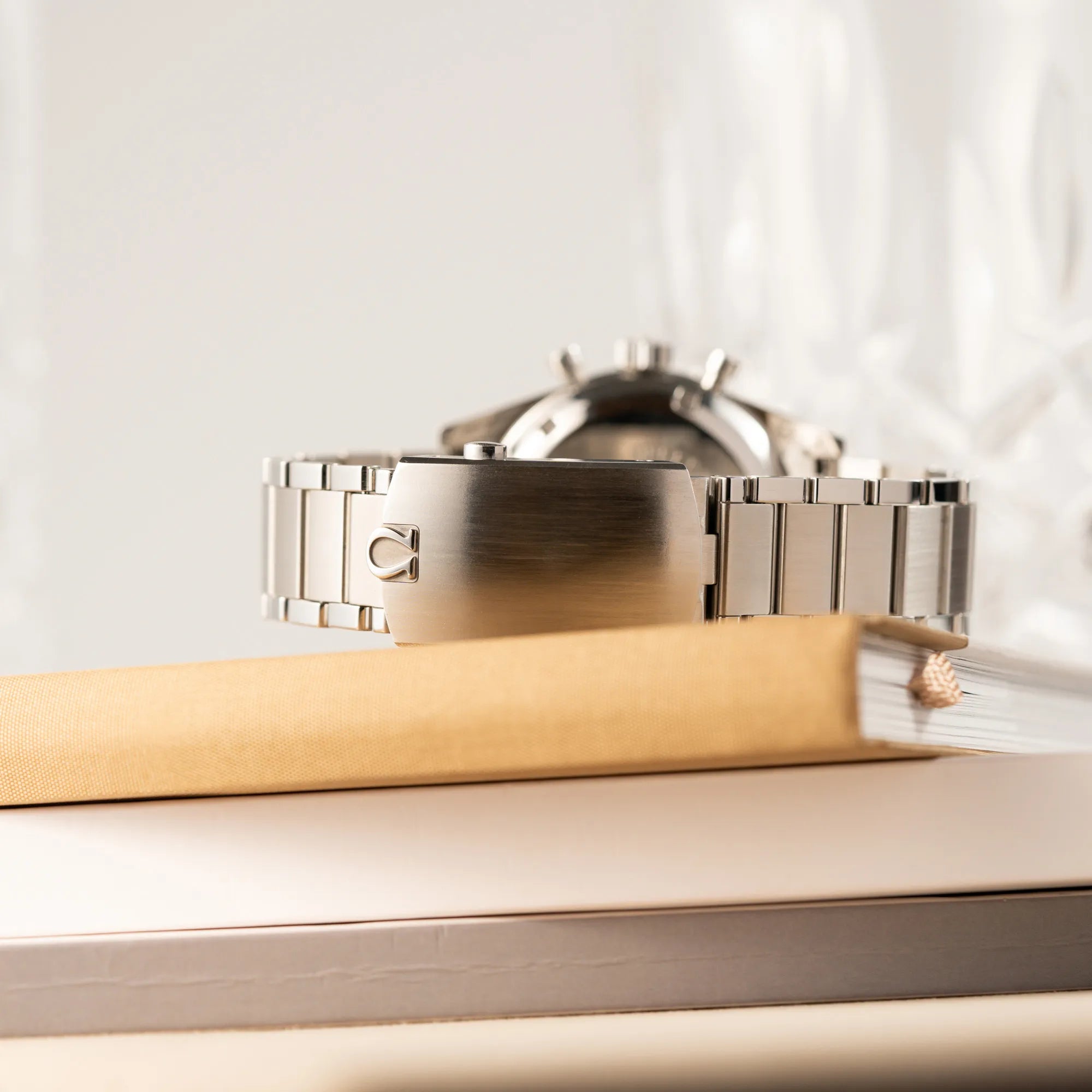 Produktfotografie der Omega Speedmaster 1957 Trilogy Limited Edition mit einem anthrazitfarbenen Zifferblatt mit Vintage-Look und dem original Omega-Stahlband im Ed-White-Design zeigt die Faltschliesse