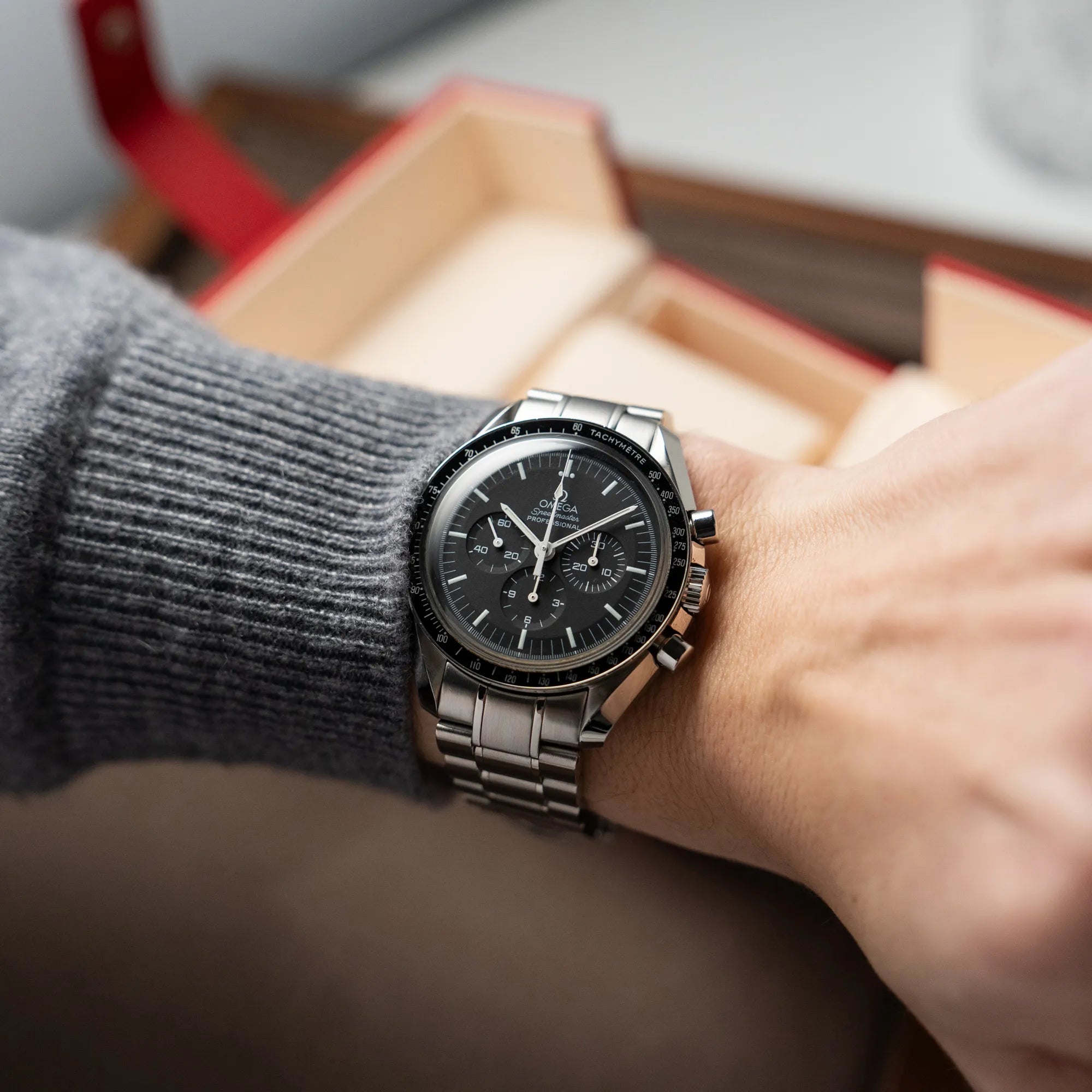 Mann trägt die klassische Omega Speedmaster Professional Moonwatch mit Hesalitglas für einen Wristhot an seinem Handgelenk