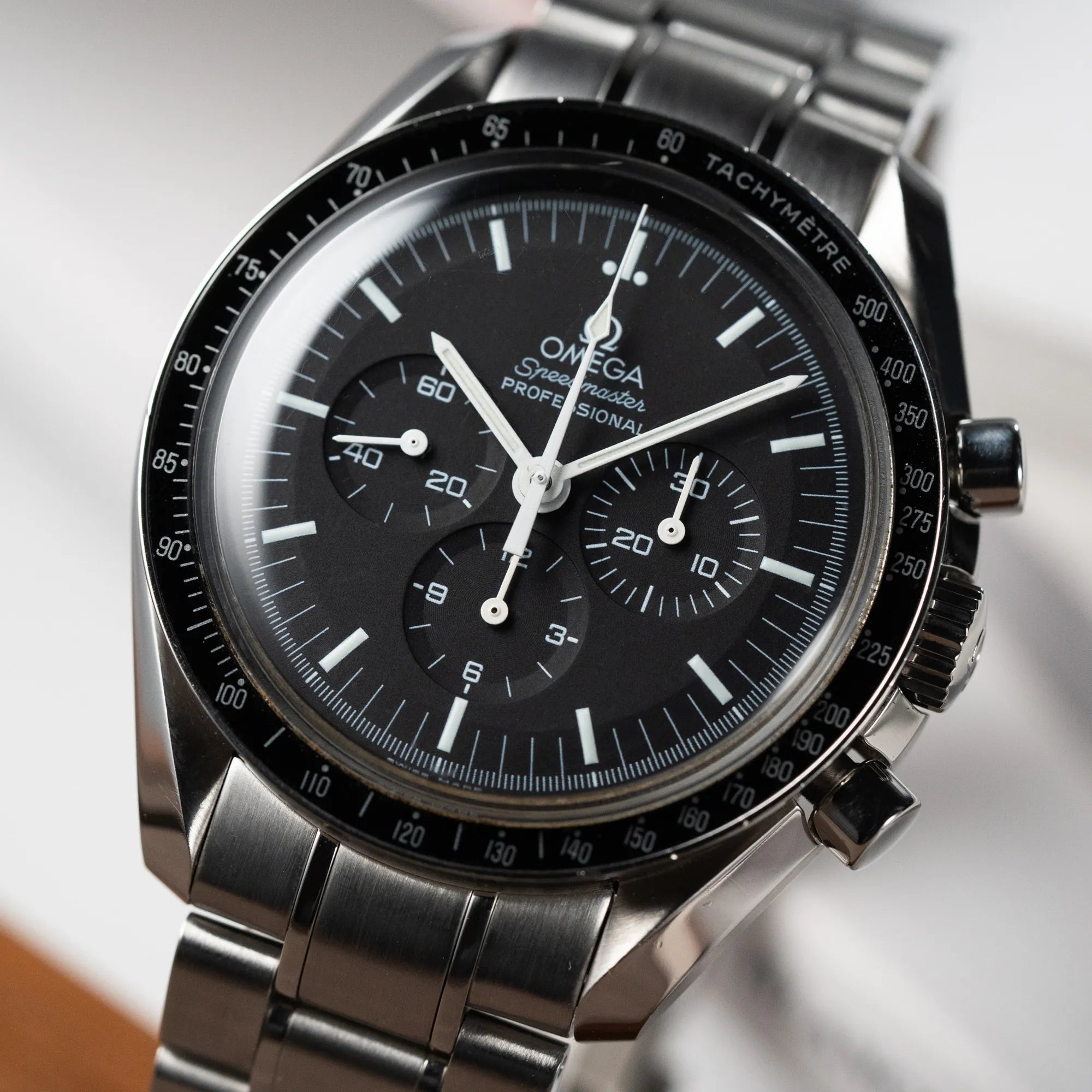 Detailaufnahme der klassischen Omega Speedmaster Professional Moonwatch mit Hesalitglas