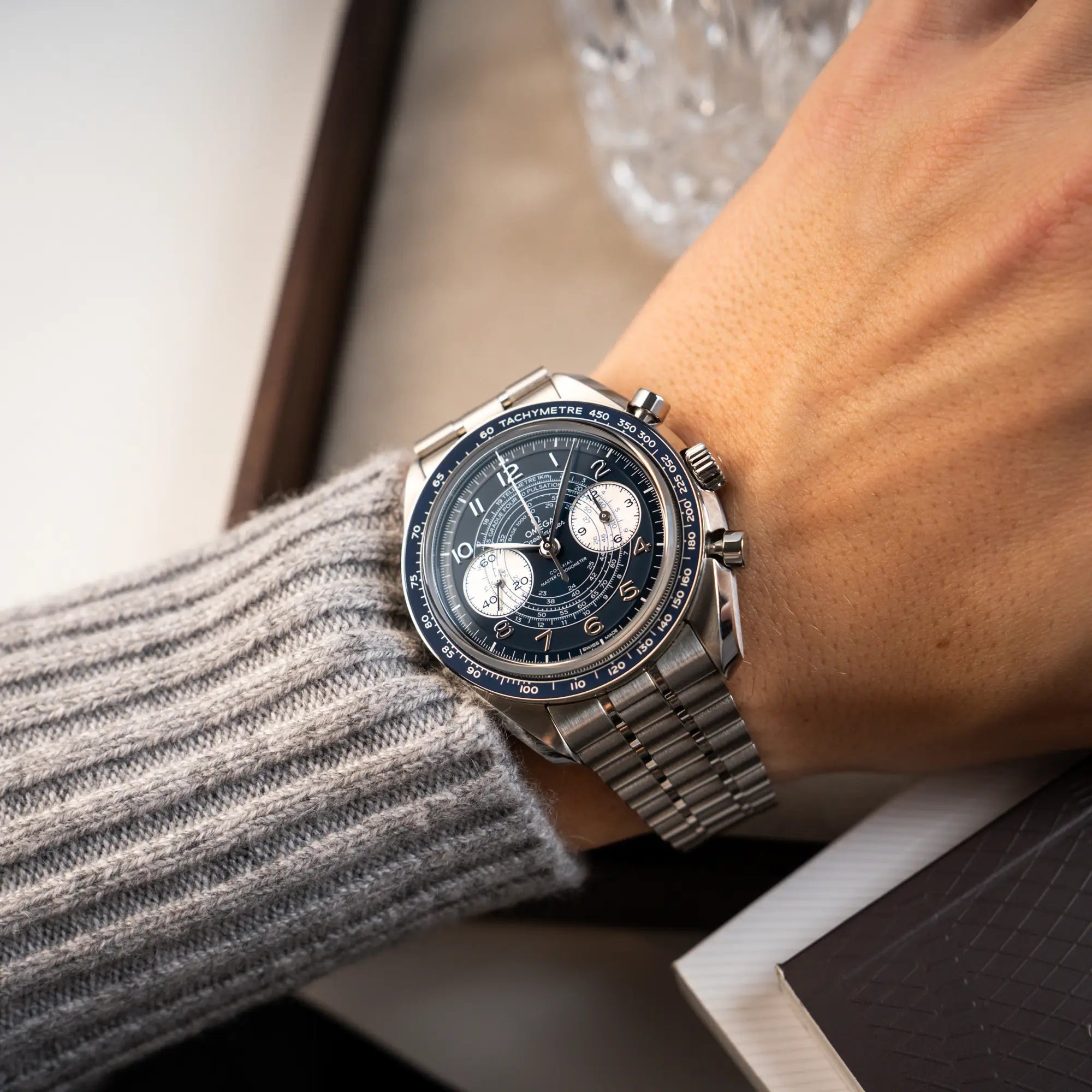 Wristshot mit der Omega Speedmaster Chronoscope aus Edelstahl mit blauem Zifferblatt und Pulsometerskala, sowie Telemeterskalaan einem Männerhandgelenk