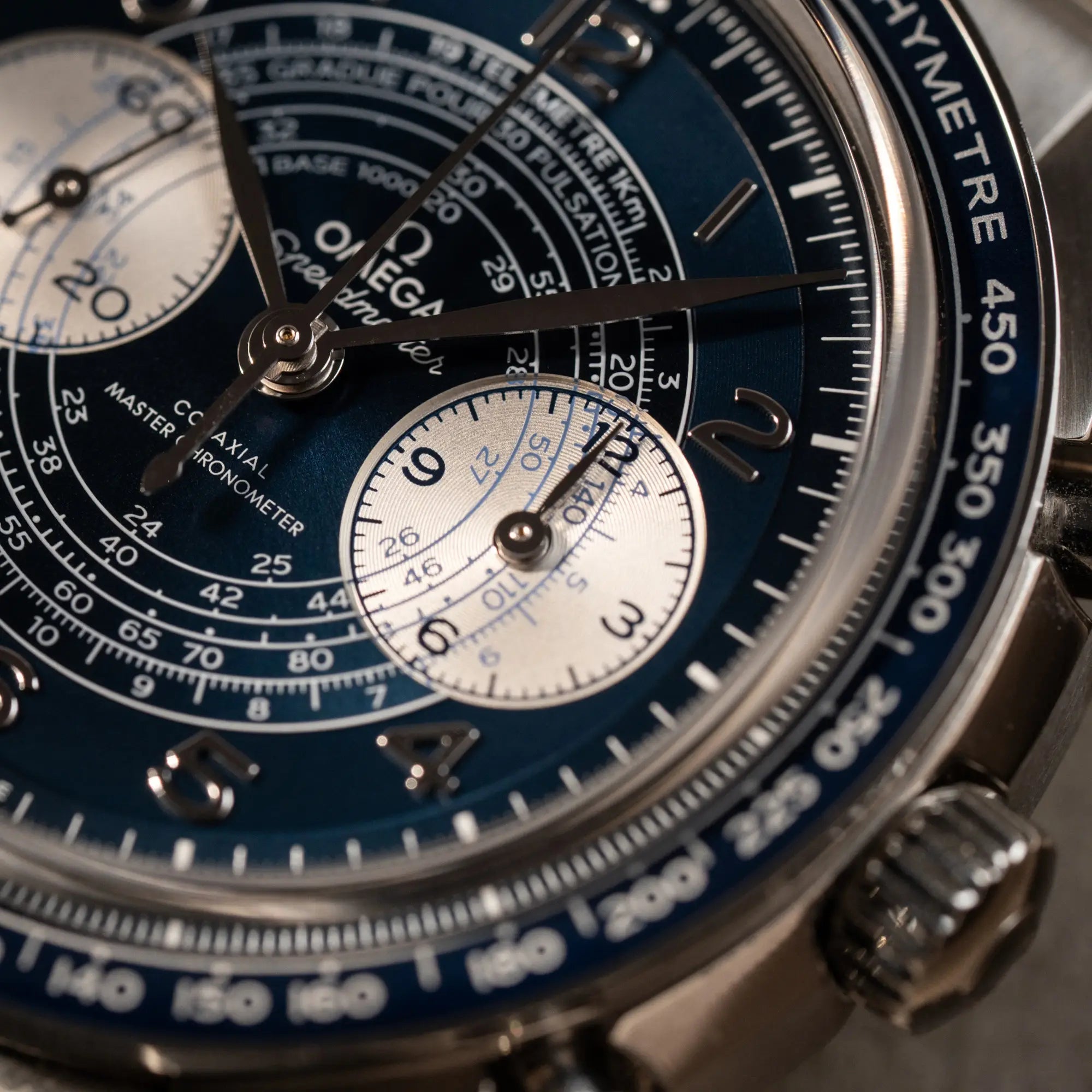 Makroaufnahme der Omega Speedmaster Chronoscope aus Edelstahl mit blauem Zifferblatt und Pulsometerskala, sowie Telemeterskala