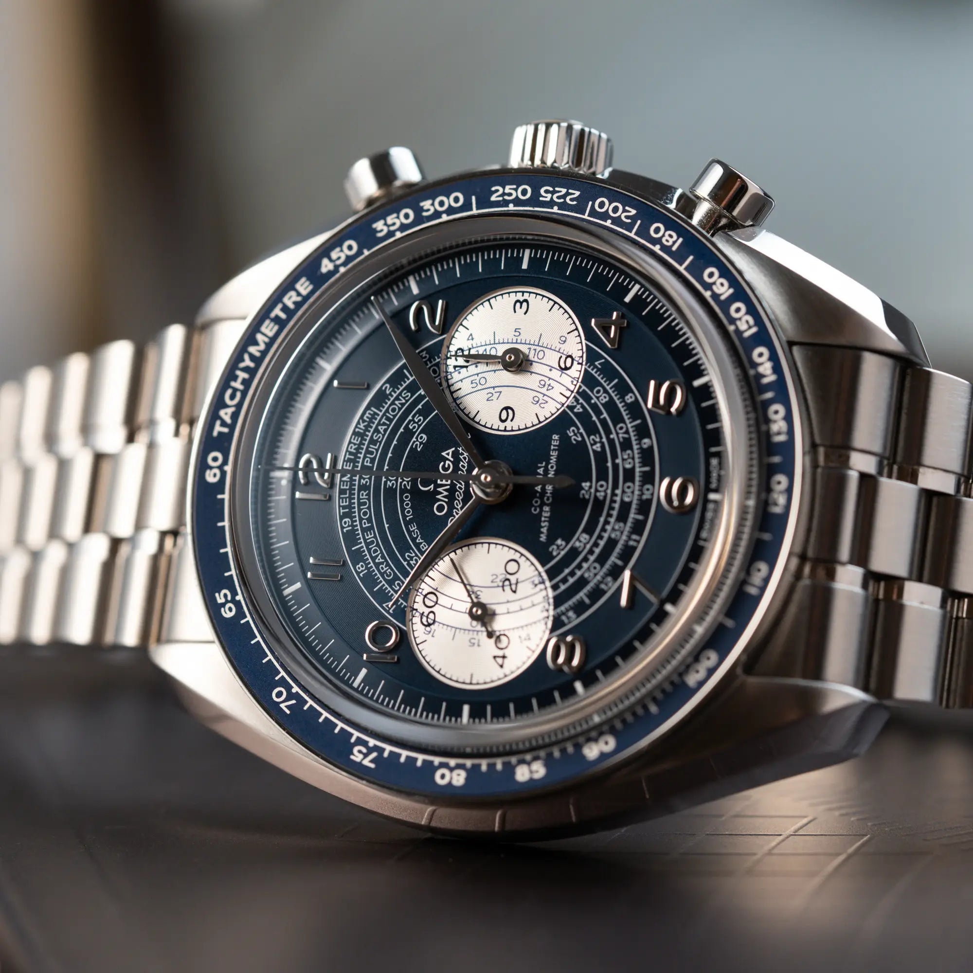 Seitlich auf dem Uhrengehäuse liegende Omega Speedmaster Chronoscope aus Edelstahl mit blauem Zifferblatt und Pulsometerskala, sowie Telemeterskala