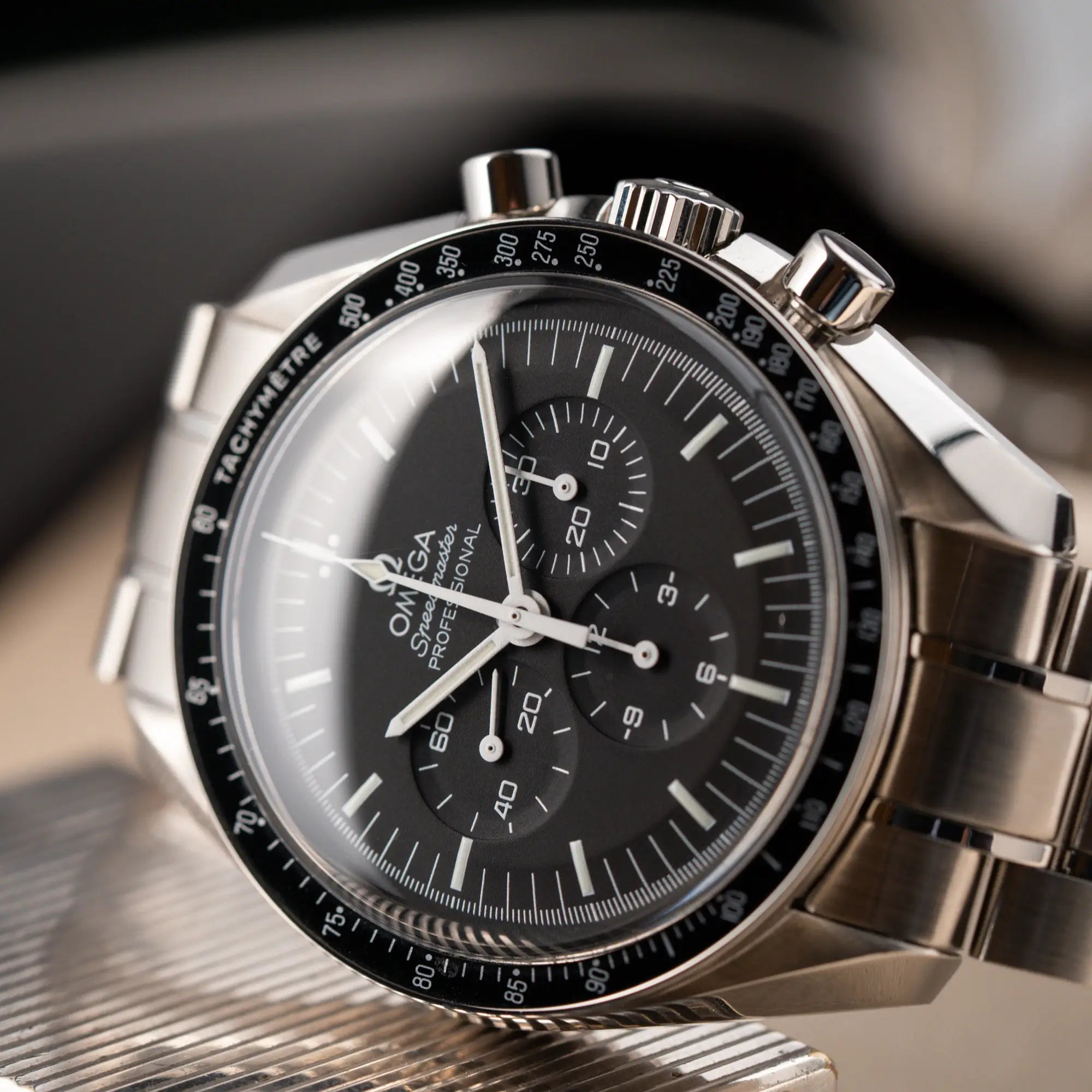 Detailaufnahme des Uhrenkopfes von der Omega Speedmaster Professional Moonwatch mit Hesalitglas aus 2018