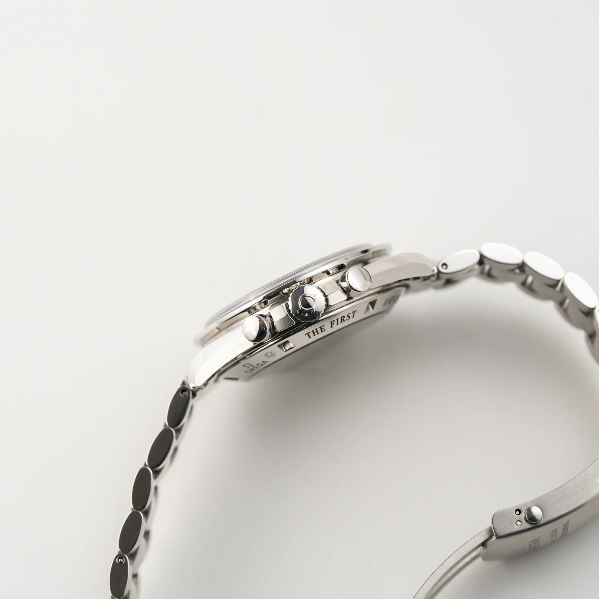 Seitliche Gehäusflanke der Omega Speedmaster Professional Moonwatch mit einem braunen Zifferblatt mit Blick auf die Aufzugskrone und die Chronograph-Drücker