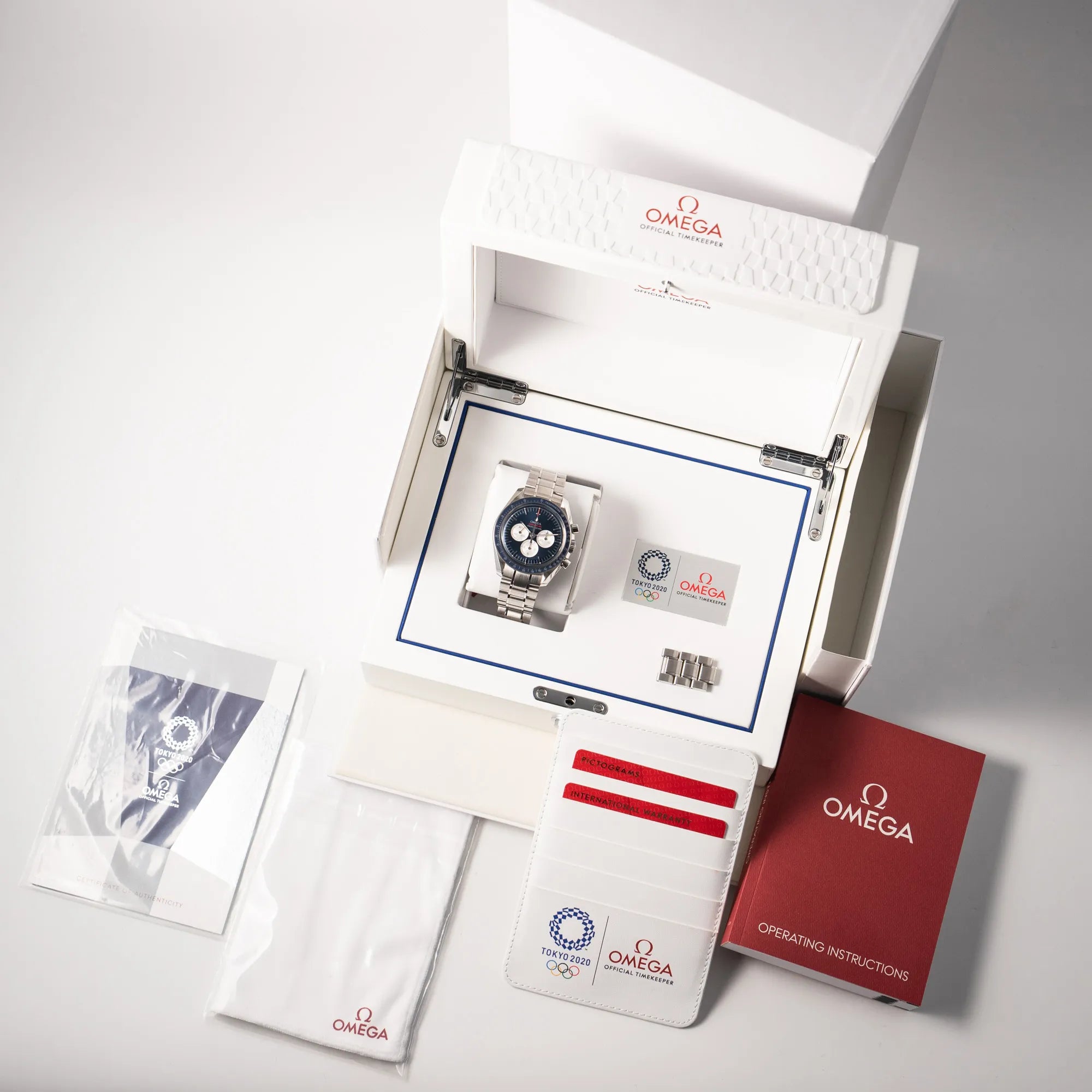Lieferumfang zu der Omega Speedmaster Professional Moonwatch Tokyo Limited Edition mit blauem Zifferblatt und weißen Sub-Dials