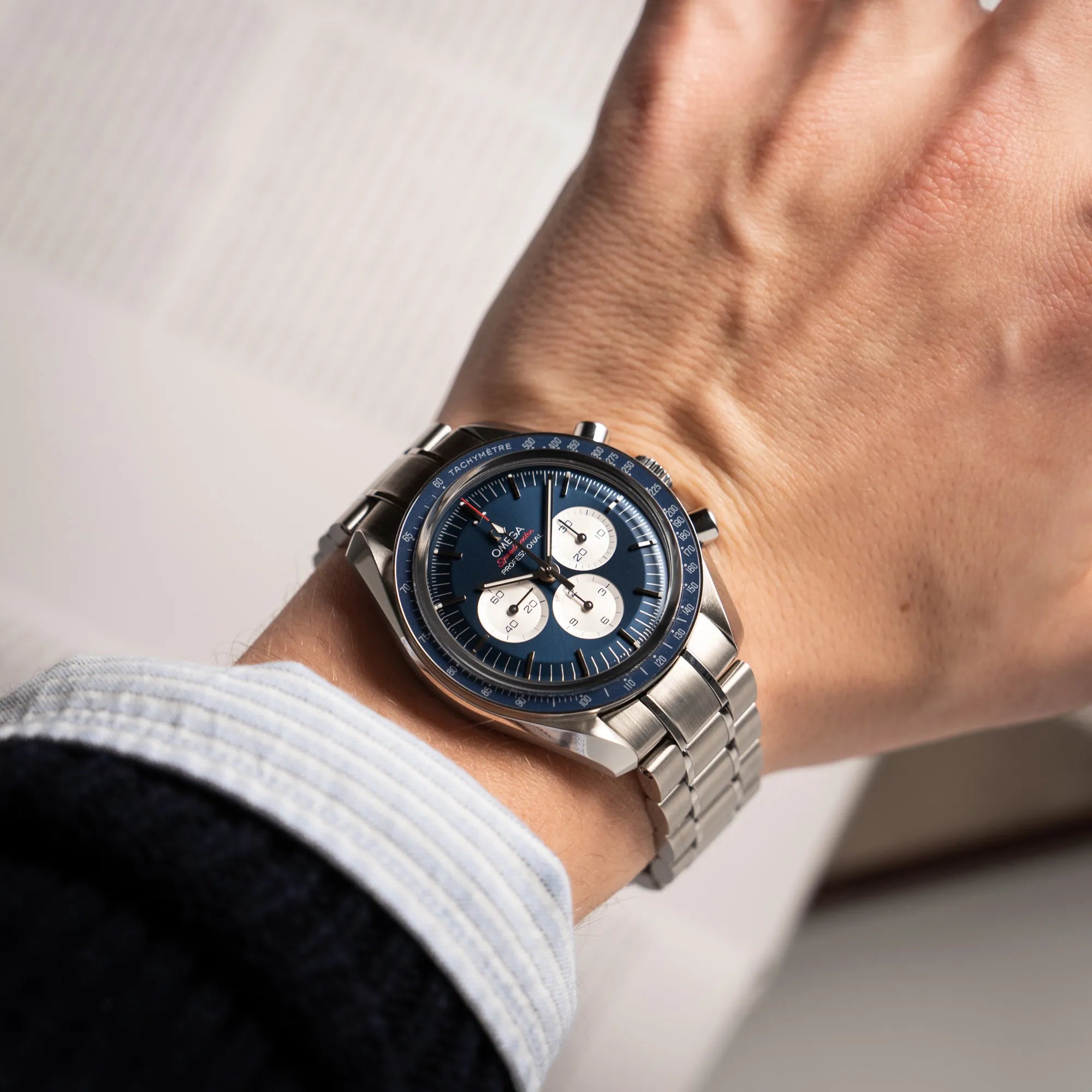 Wristshot mit der Omega Speedmaster Professional Moonwatch Tokyo Limited Edition mit blauem Zifferblatt und weißen Sub-Dials an einem Männerhandgelenk