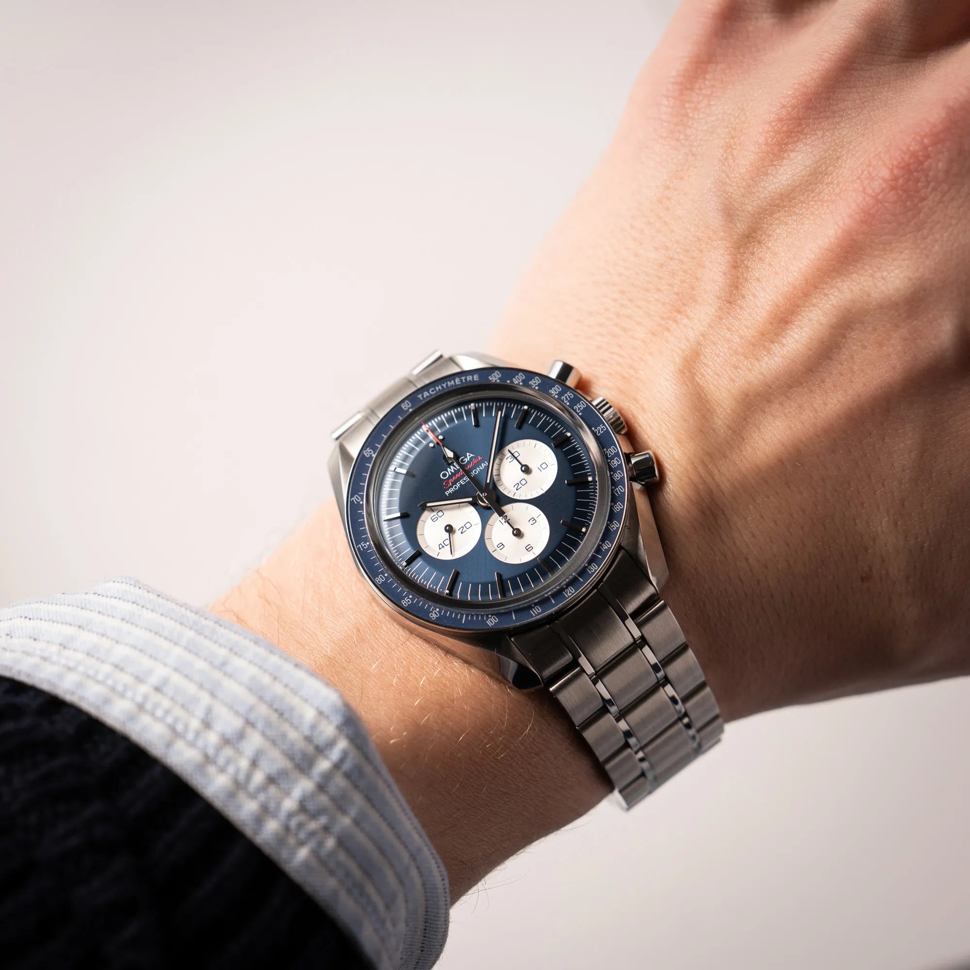 Wristshot mit der Omega Speedmaster Professional Moonwatch Tokyo Limited Edition mit blauem Zifferblatt und weißen Sub-Dials am Handgelenk