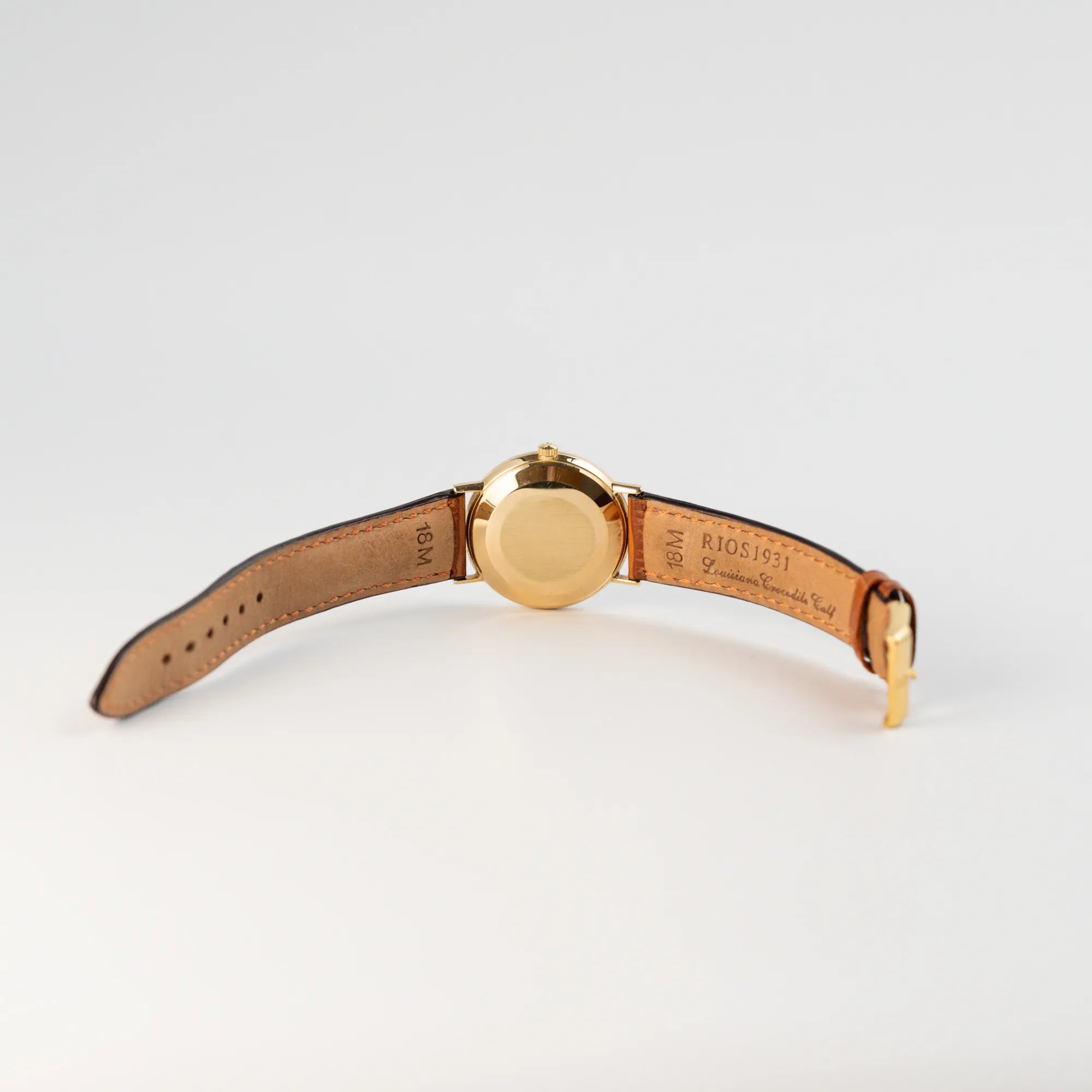 Blick auf den Gehäuseboden und die geöffnete Dornschliesse am RIOS Lederband der Omega Vintage Automatik Armbanduhr mit Gelbgold-Gehäuse