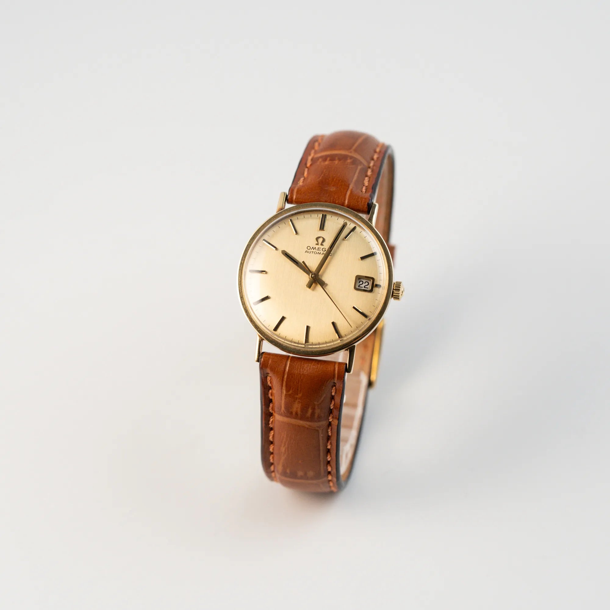 Leicht schräge Ansicht der Omega Vintage Automatik Armbanduhr mit Gelbgold-Gehäuse