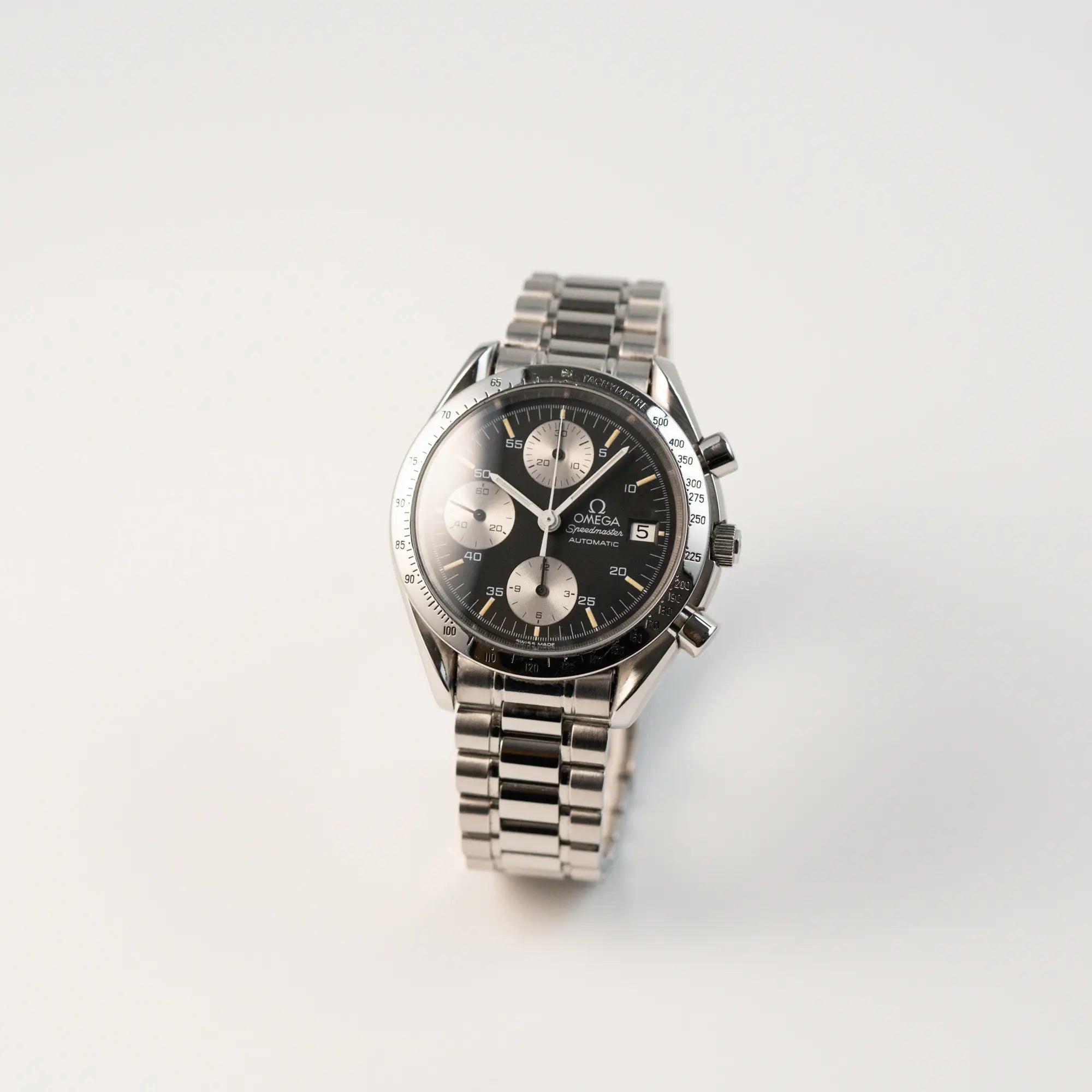 Leicht schräge Ansicht der Omega Speedmaster Automatic Date mit schwarzem Zifferblatt und silbernen Totalisatoren
