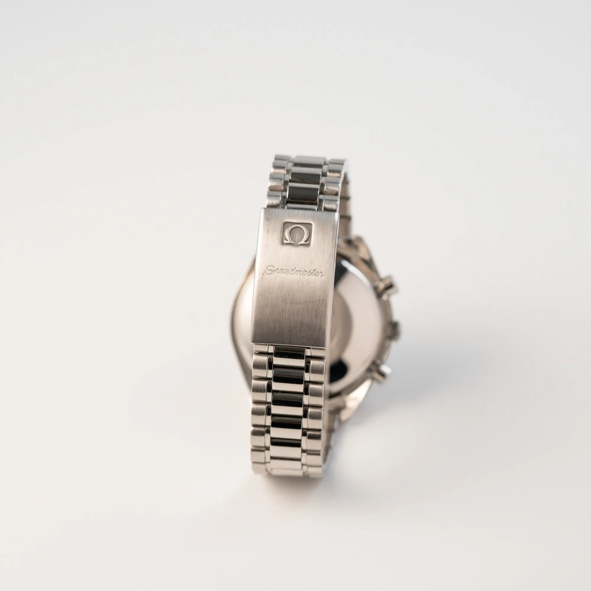 Rückseite der Omega Speedmaster Automatic Date mit schwarzem Zifferblatt und silbernen Totalisatoren mi Blick auf das originale Omega Edelstahl-Armband