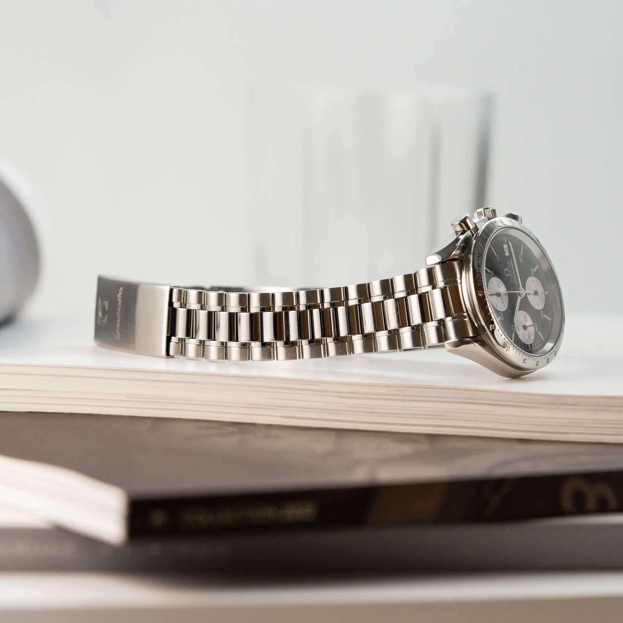 Produktfotografie der Omega Speedmaster Automatic Date mit schwarzem Zifferblatt und silbernen Totalisatoren zeigt den Zustand und Stretch des Armbandes