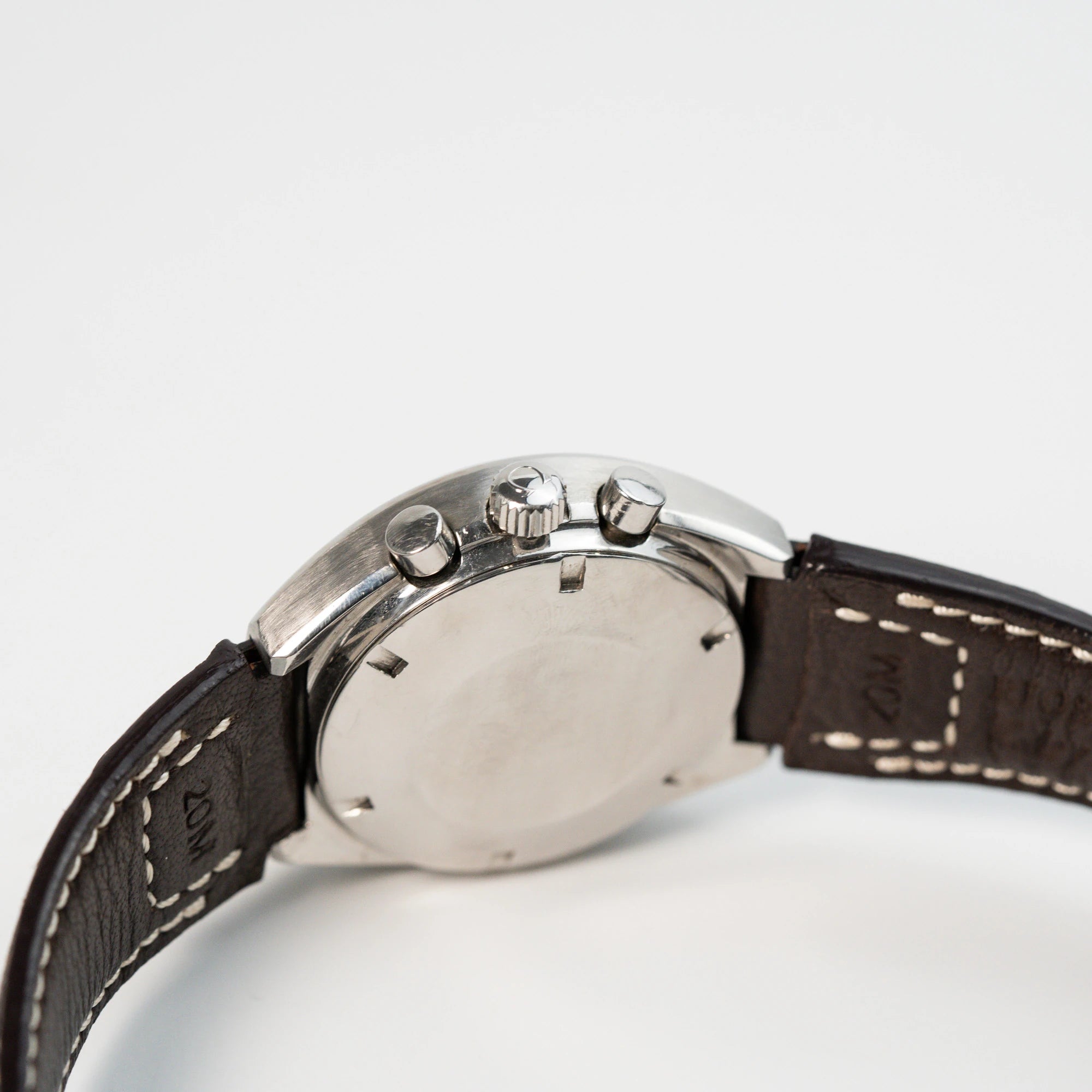 Seitliches Gehäuse mit Blick auf die Krone und die Chronograph-Pusher der Omega Speedmaster Moonwatch Mark 2 an einem braunen Lederarmband