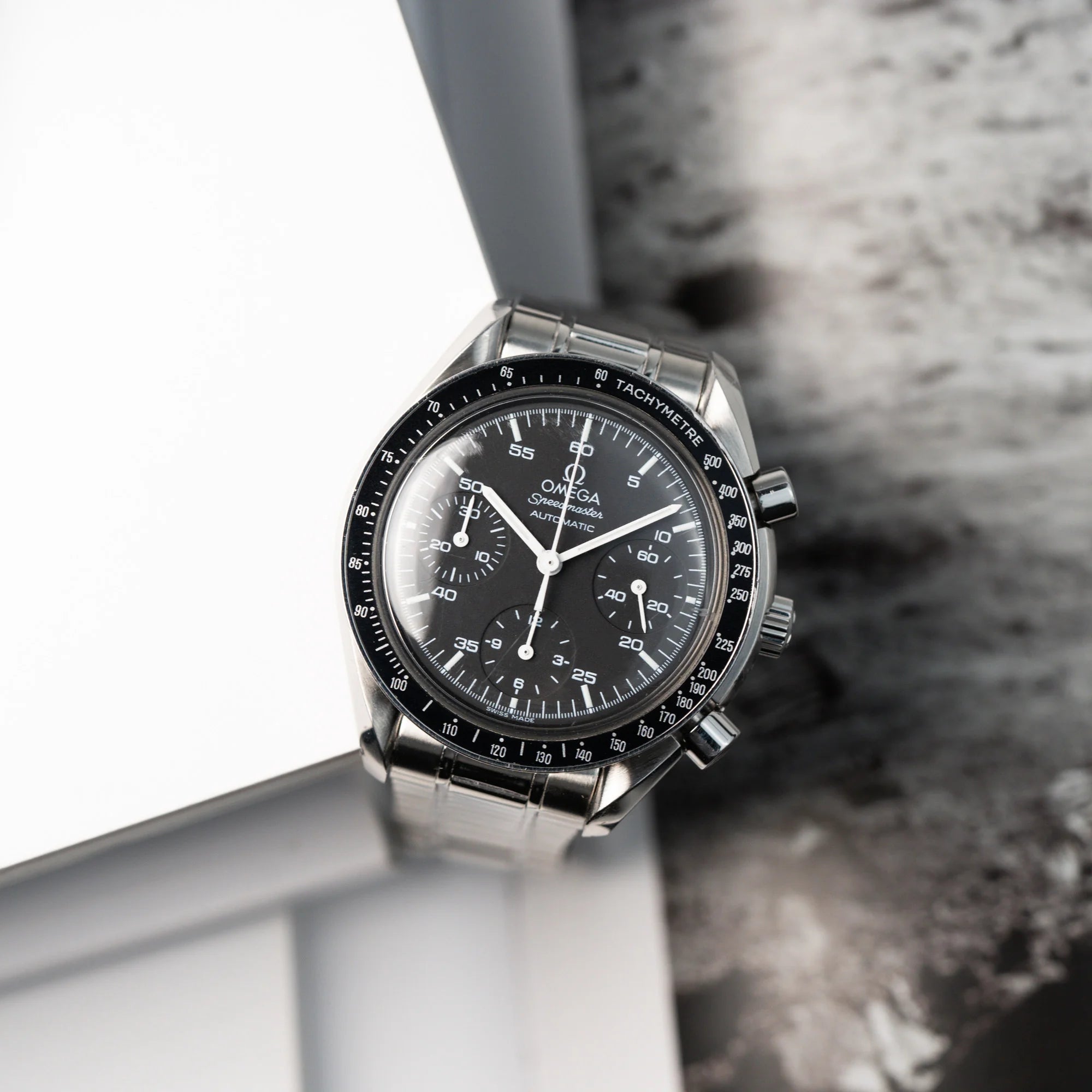 Draufsicht auf die Omega Speedmaster Reduced mit schwarzem Zifferblatt und weißen Indizes