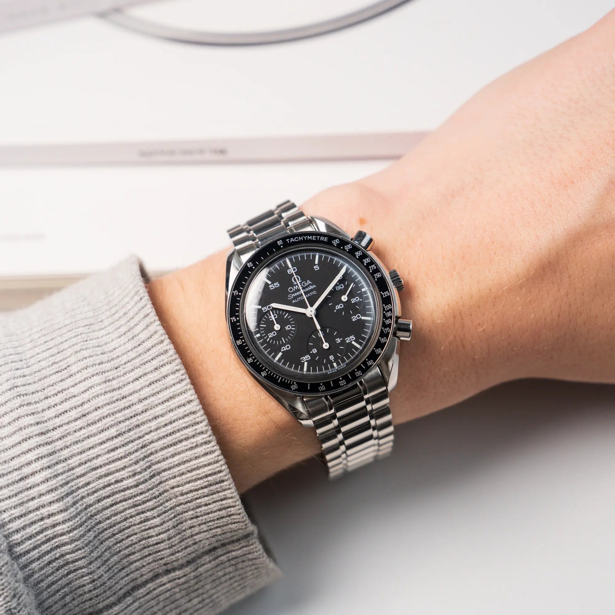 Wristshot mit der Omega Speedmaster Reduced mit einem schwarzen Zifferblatt und weißen Indizes