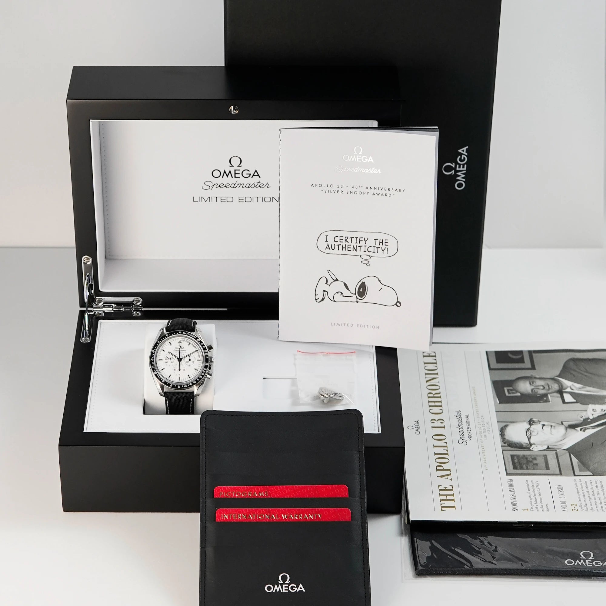 Omega Speedmaster Moonwatch Silver Snoopy mit dem weißen Zifferblatt zusammen mit dem Lieferumfang, bestehend aus Box, Papieren, einem Snoppy-Pin, sowie allen Booklets - absolutes Full-Set