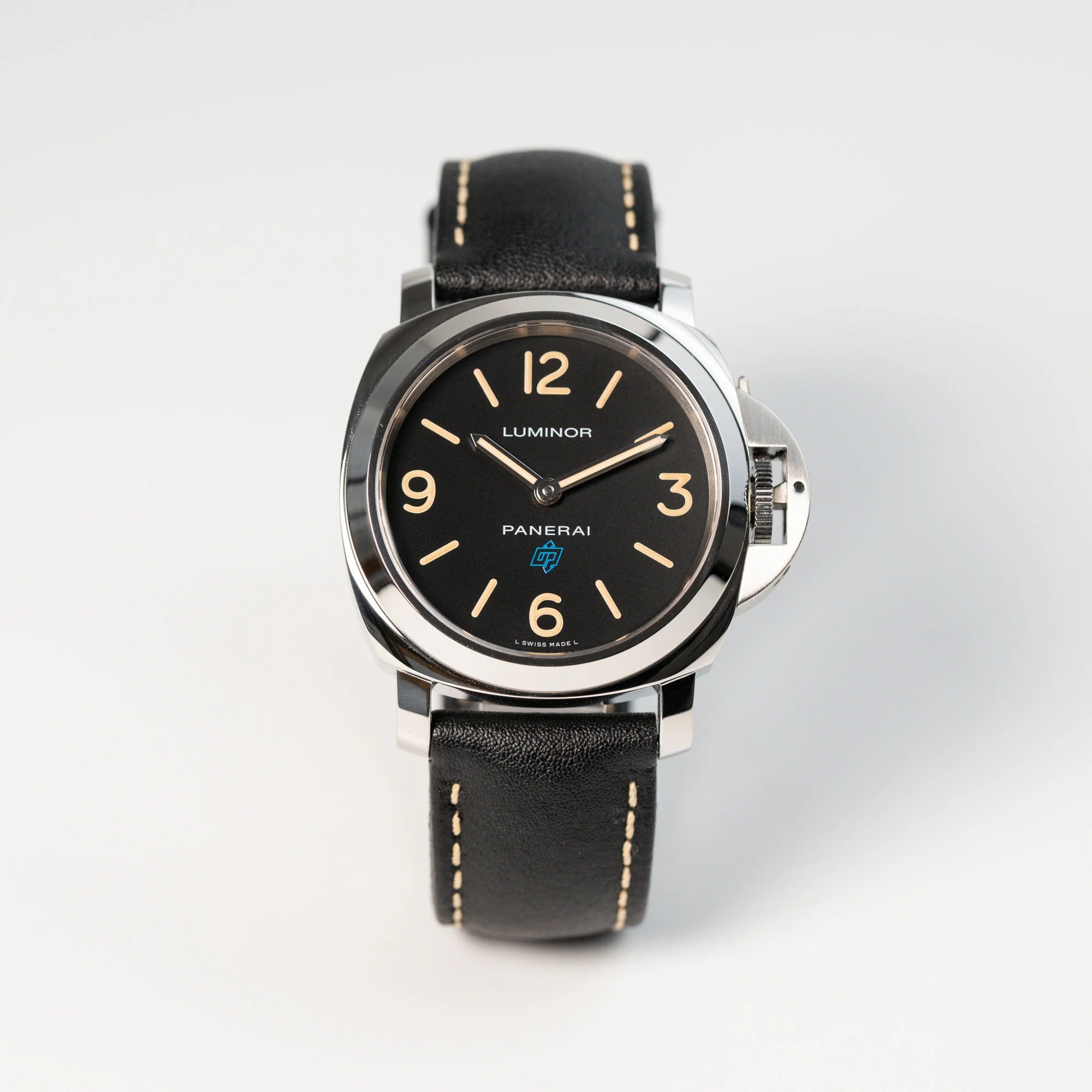 Frontale Ansicht der Panerai Luminor Logo Base mit schwarzem Zifferblatt und beigen Indizes, sowie einen schwarzem Lederband